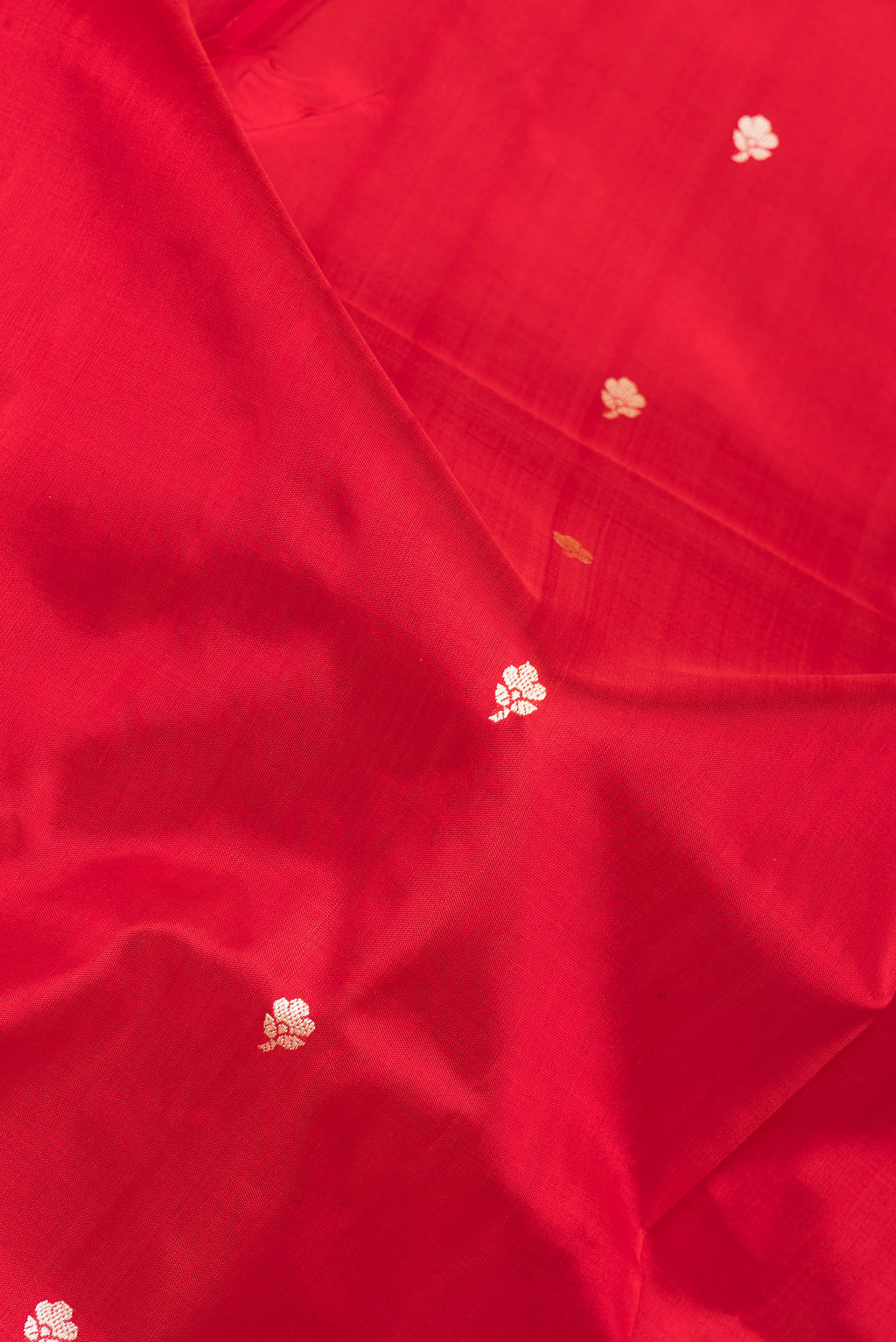 Close up of Red Banarasi Katan Silk Saree with Thread Butta on the body and Thread Border.  displaying folds