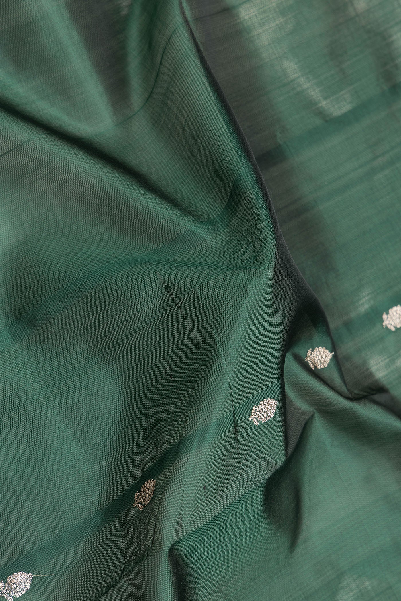 Close up of Bottle Green Dual Tone Banarasi Silk Saree with Zari Butta on the body and Zari Border.  displaying folds