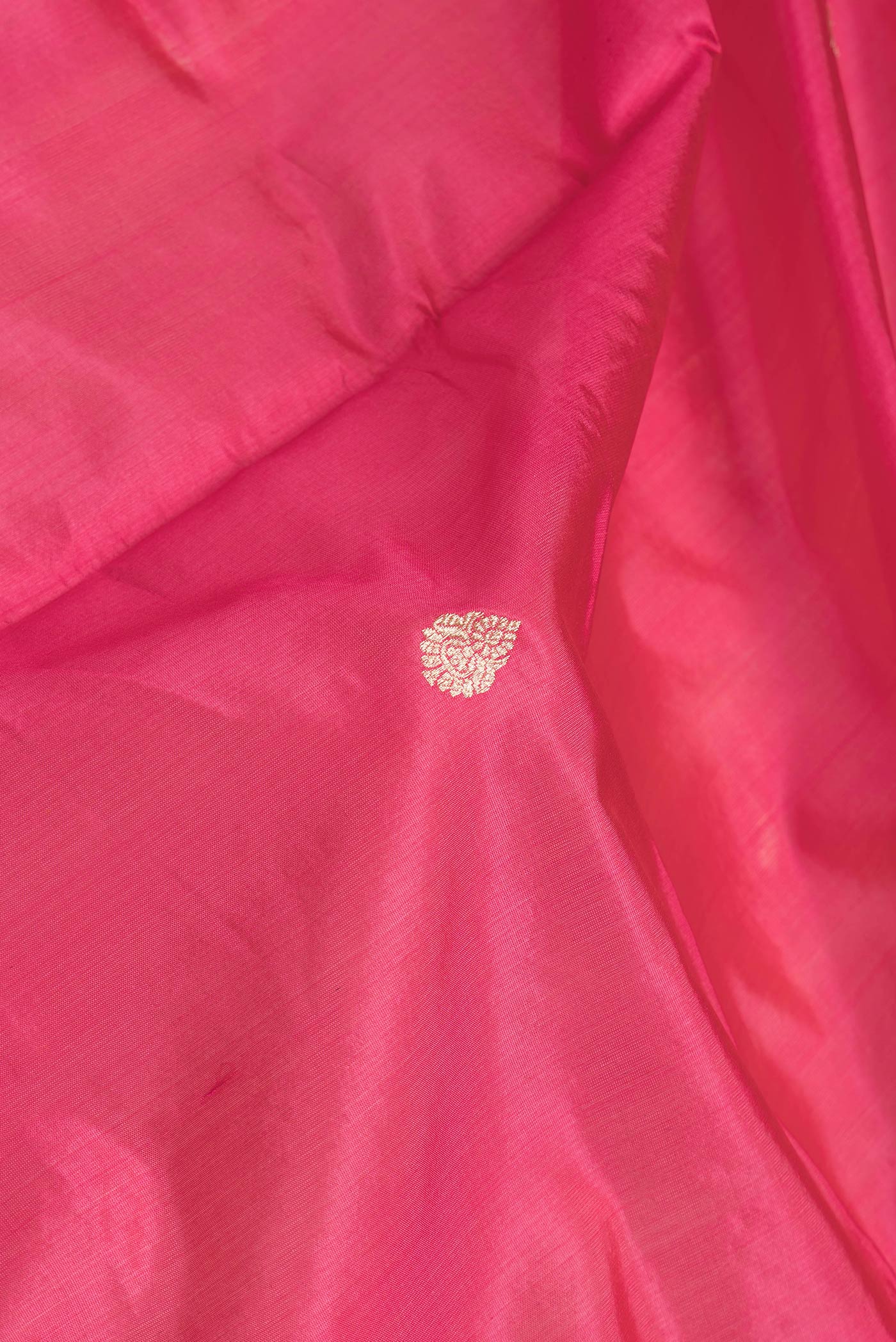 Close up of Pink Dual Tone Banarasi Silk Saree with Zari Butta on the body and Zari Border.  displaying folds