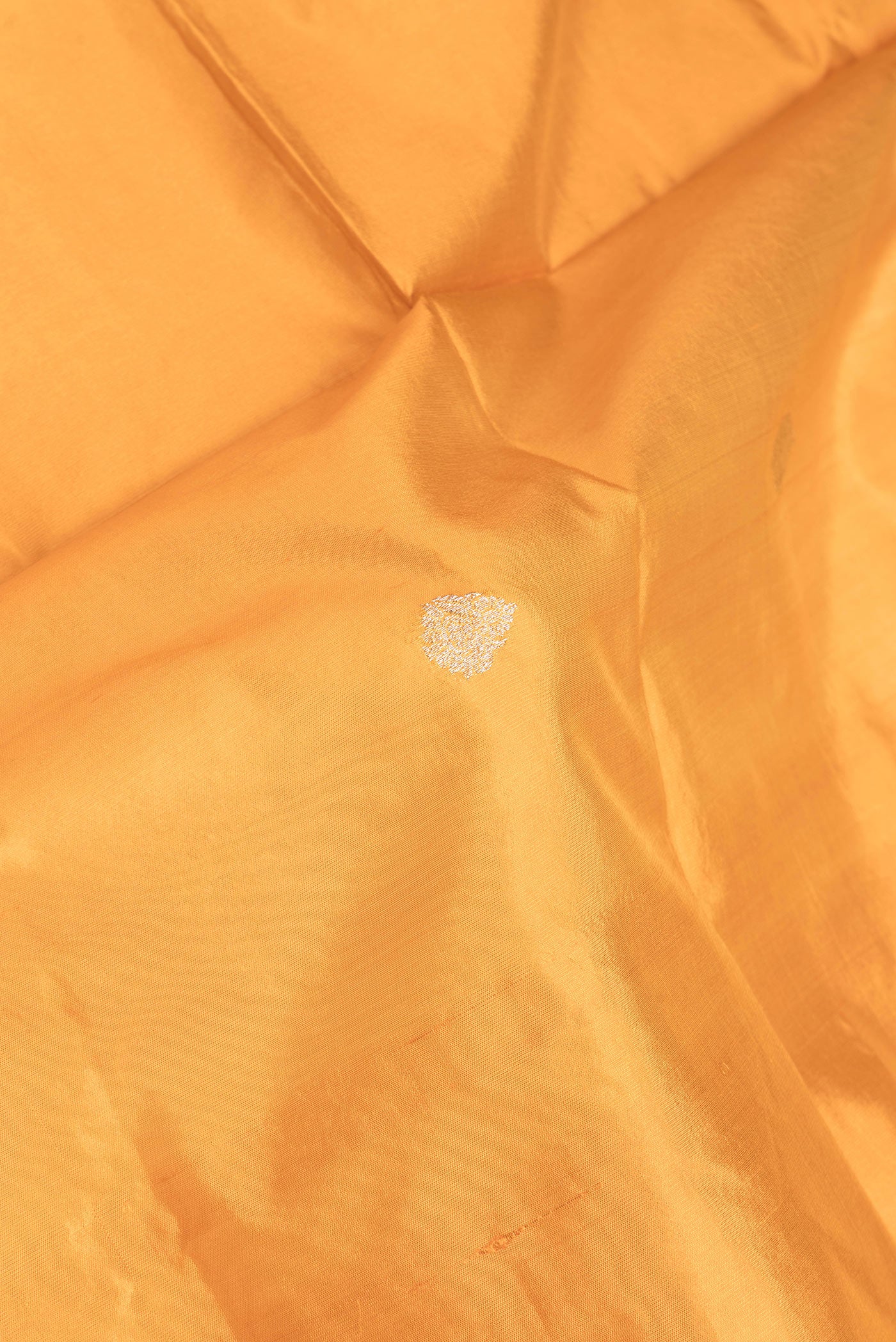 Close up of Mustard Dual Tone Banarasi Silk Saree with Zari Butta on the body and Zari Border.  displaying folds