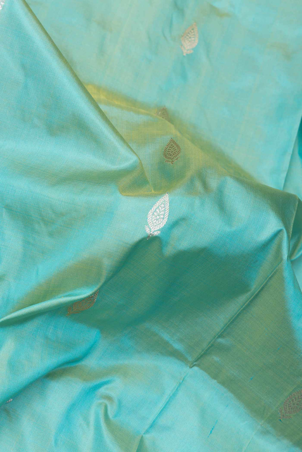 Close up of Pista Green Dual Tone Banarasi Silk Saree with Zari Butta on the body and Thread Border.  displaying folds