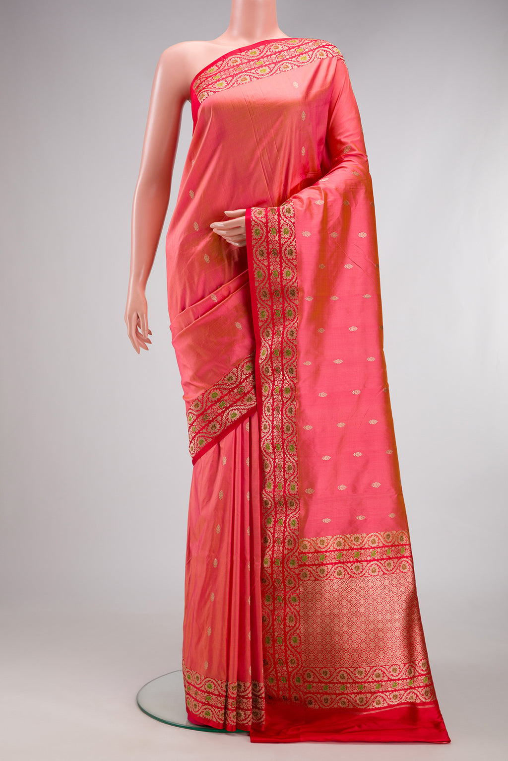 Coral Banarasi Katan Silk Saree with Zari Butta on the body and Fancy Border.  displayed on a mannequin