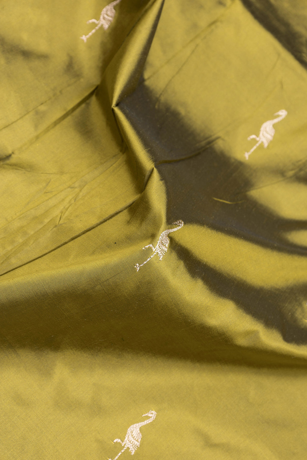 Close up of Mehandi Green Dual Tone Banarasi Silk Saree with Zari Butta on the body and Fancy Border.  displaying folds