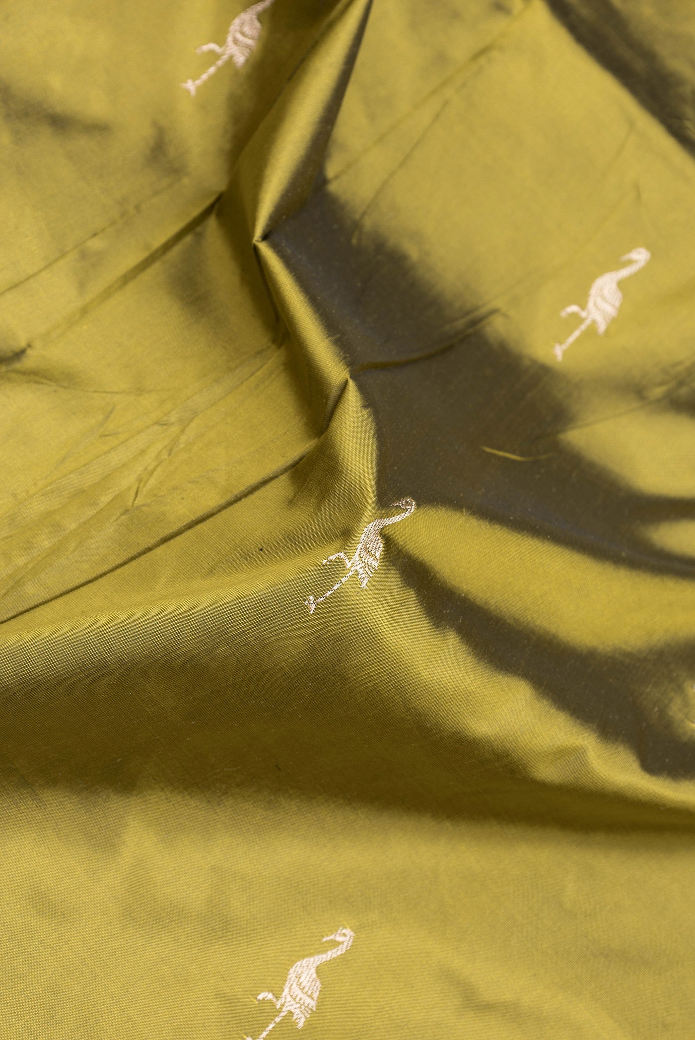 Close up of Mehandi Green Dual Tone Banarasi Silk Saree with Zari Butta on the body and Fancy Border.  displaying folds
