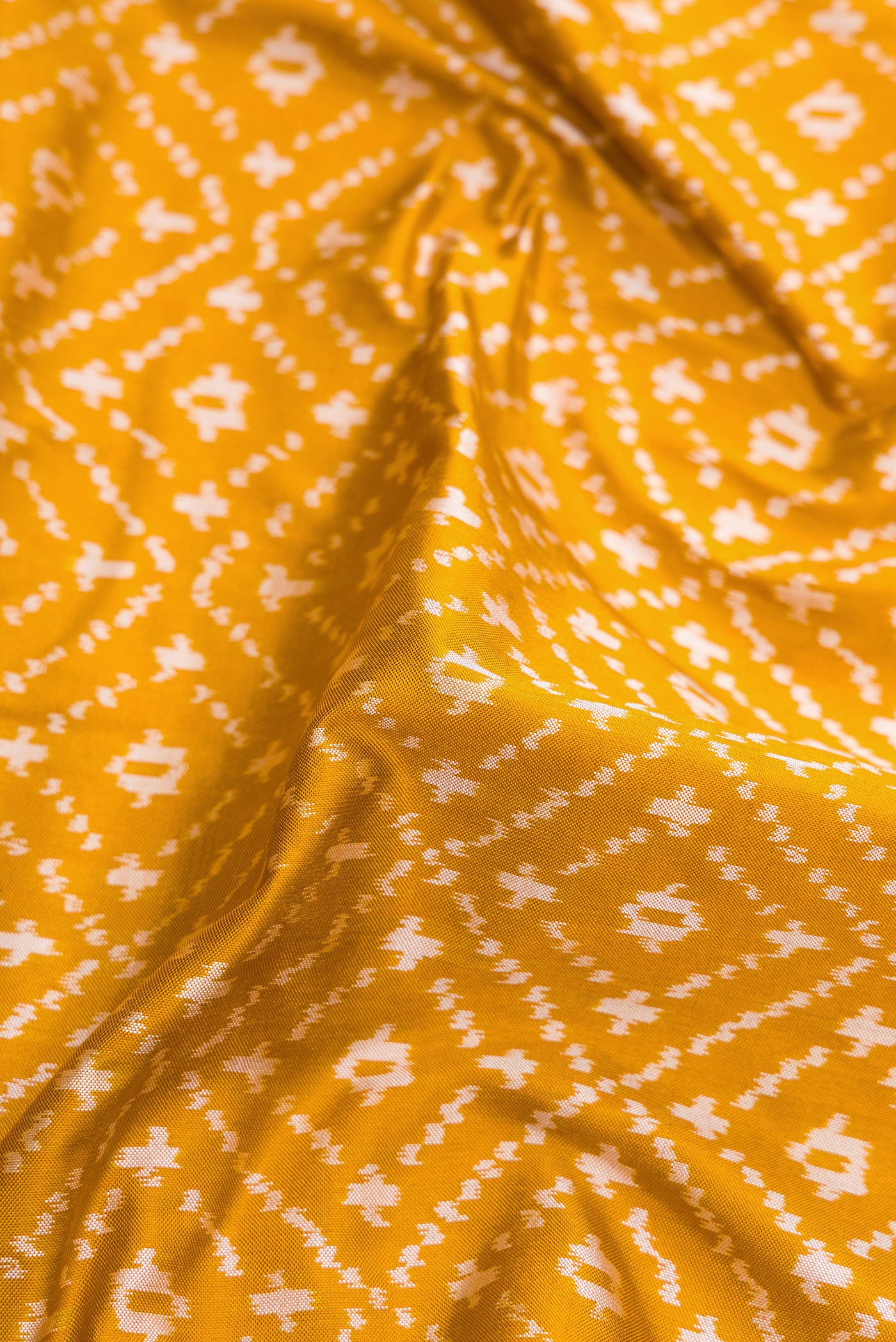Close up of Mustard Dual Tone Double Ikat Nine Yards Saree with Ikat Print on the body and Zari Border.  displaying folds