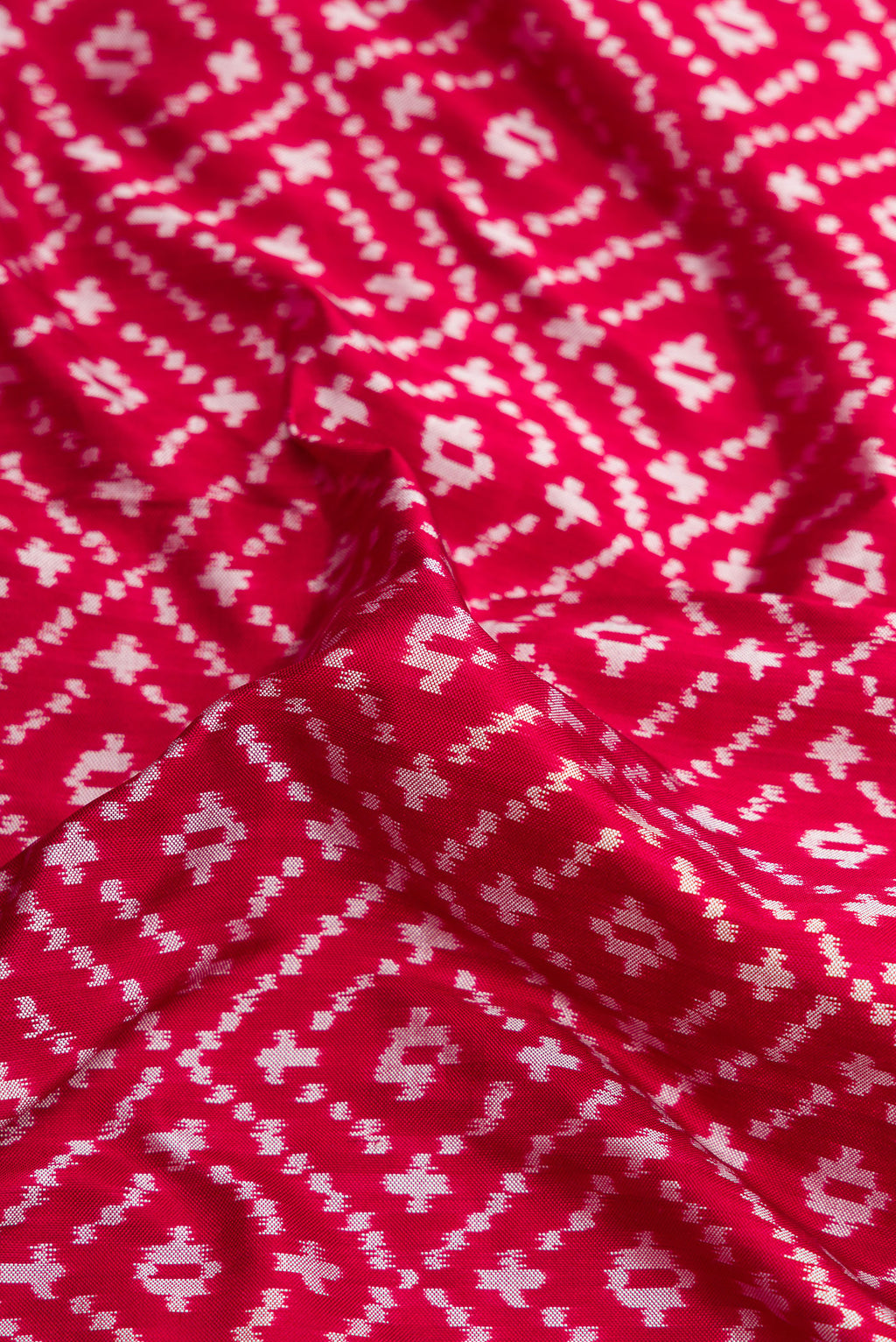 Close up of Maroon Dual Tone Double Ikat Nine Yards Saree with Ikat Print on the body and Zari Border.  displaying folds