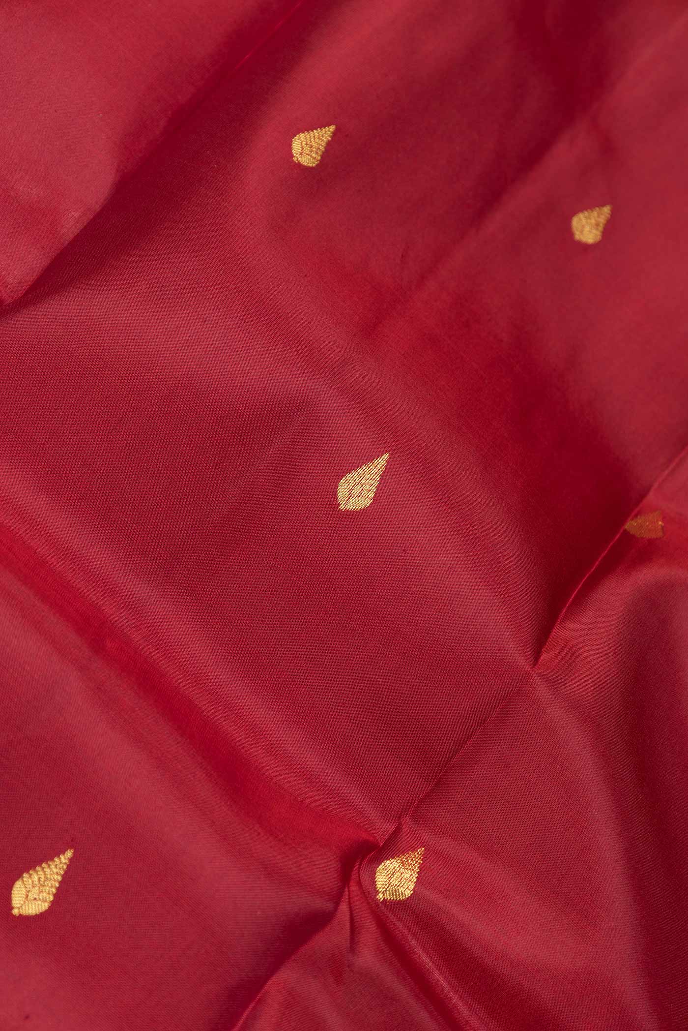 Close up of Maroon Dual Tone Kanjivaram Saree with Zari Butta on the body and Zari Border.  displaying folds