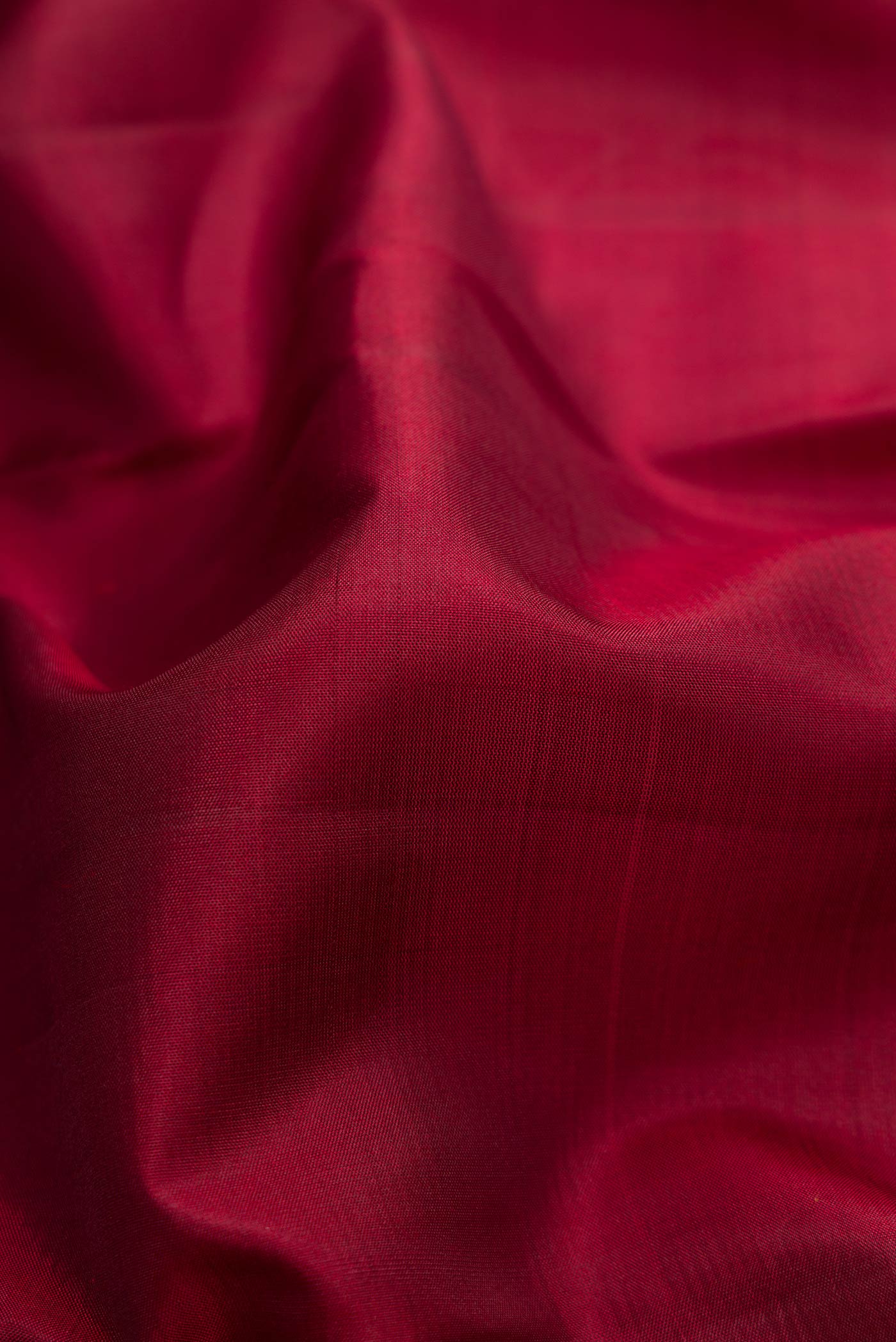 Close up of Maroon Dual Tone Kanjivaram Silk Saree with Plain Body and Zari Border.  displaying folds
