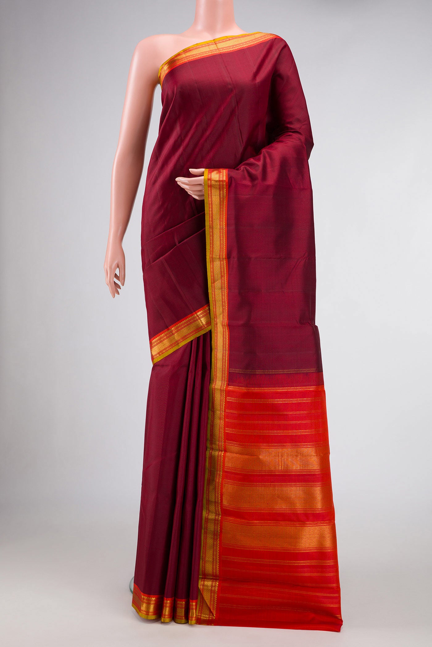 Maroon Dual Tone Kanjivaram Silk Saree with Plain Body and Zari Border.  displayed on a mannequin