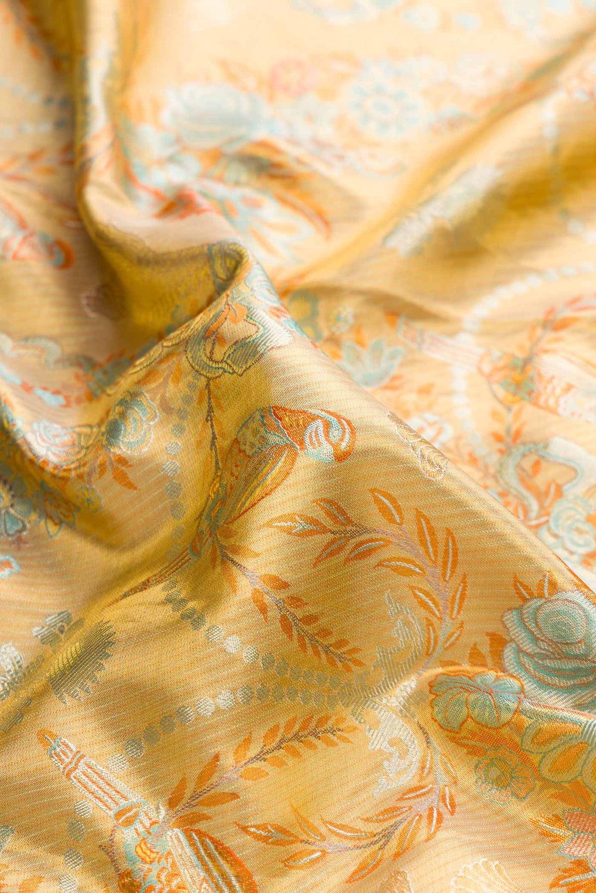 Close up of Gold Dual Tone Kanchipuram Tissue Silk Saree with Zari Brocade on the body and Zari Border displaying folds