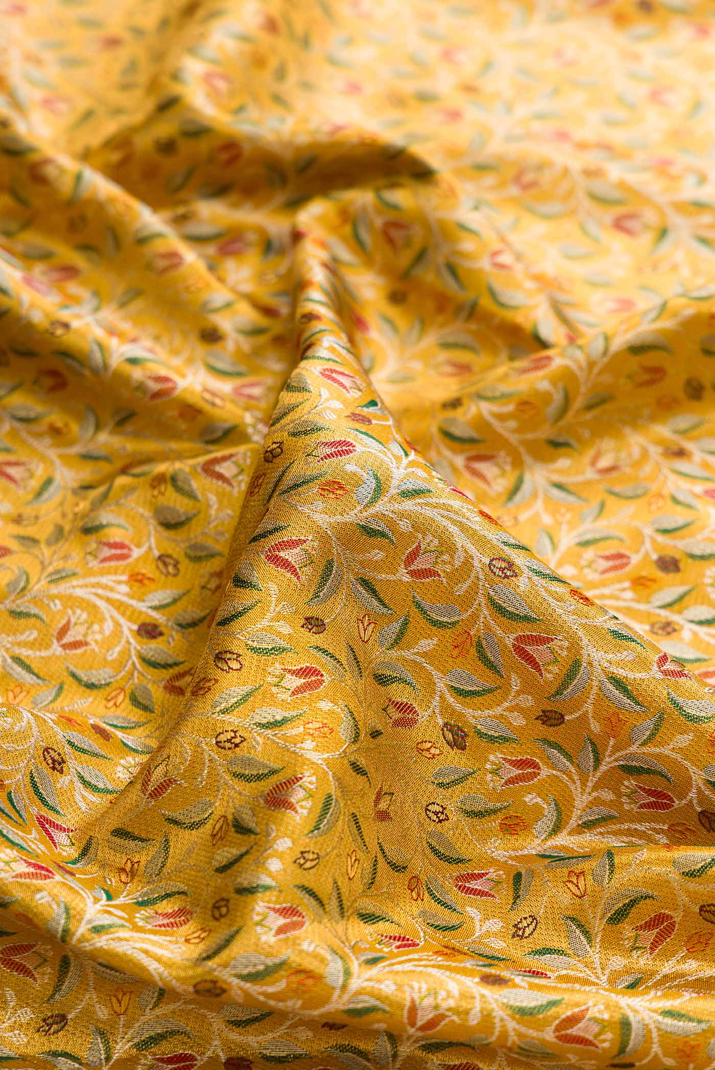 Close up of Gold Dual Tone Kanchipuram Tissue Silk Saree with Zari Brocade on the body and Fancy Border displaying folds