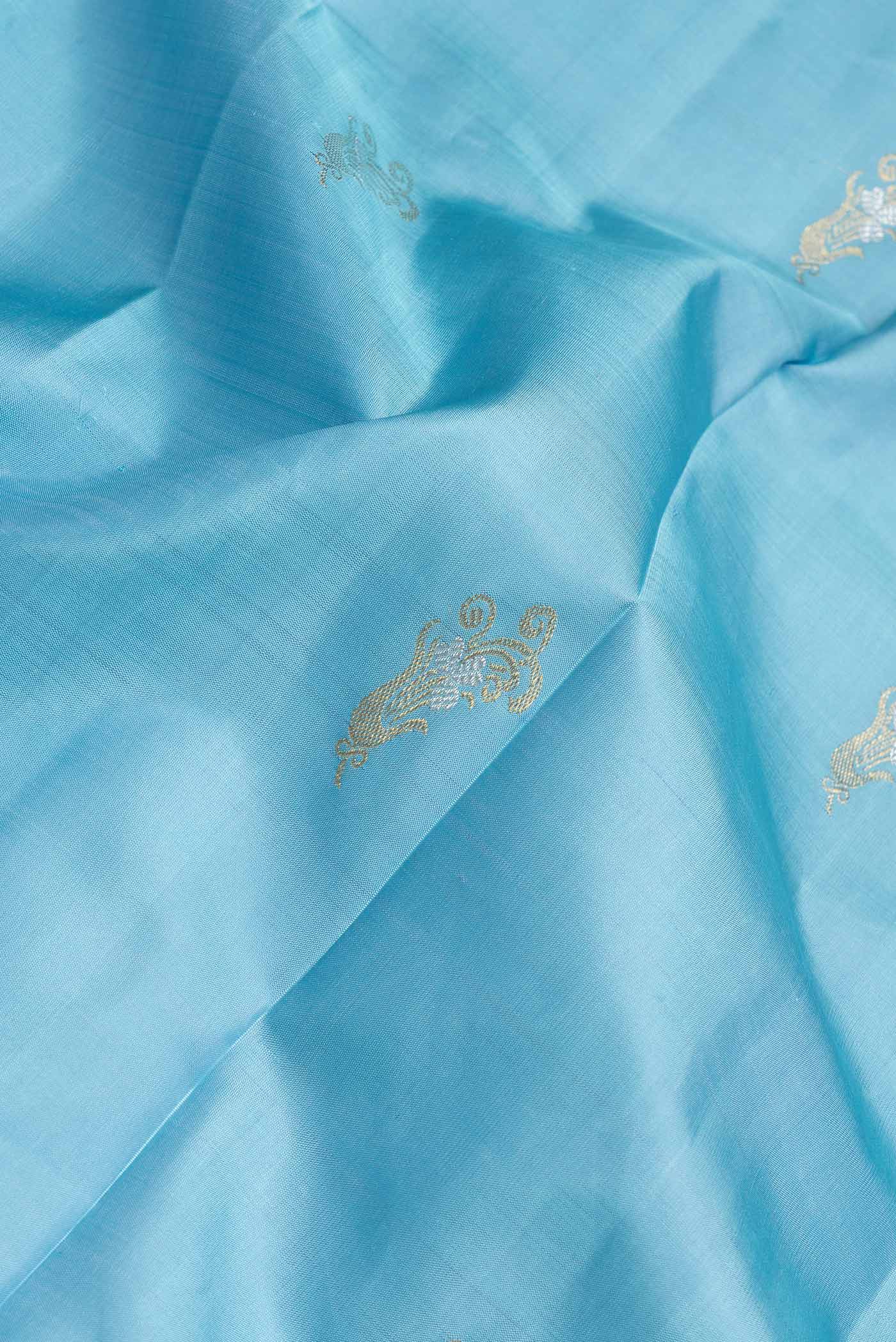 Close up of Sky Blue Dual Tone Kanchipuram Silk Saree with Zari Butta on the body and Zari Border.  displaying folds