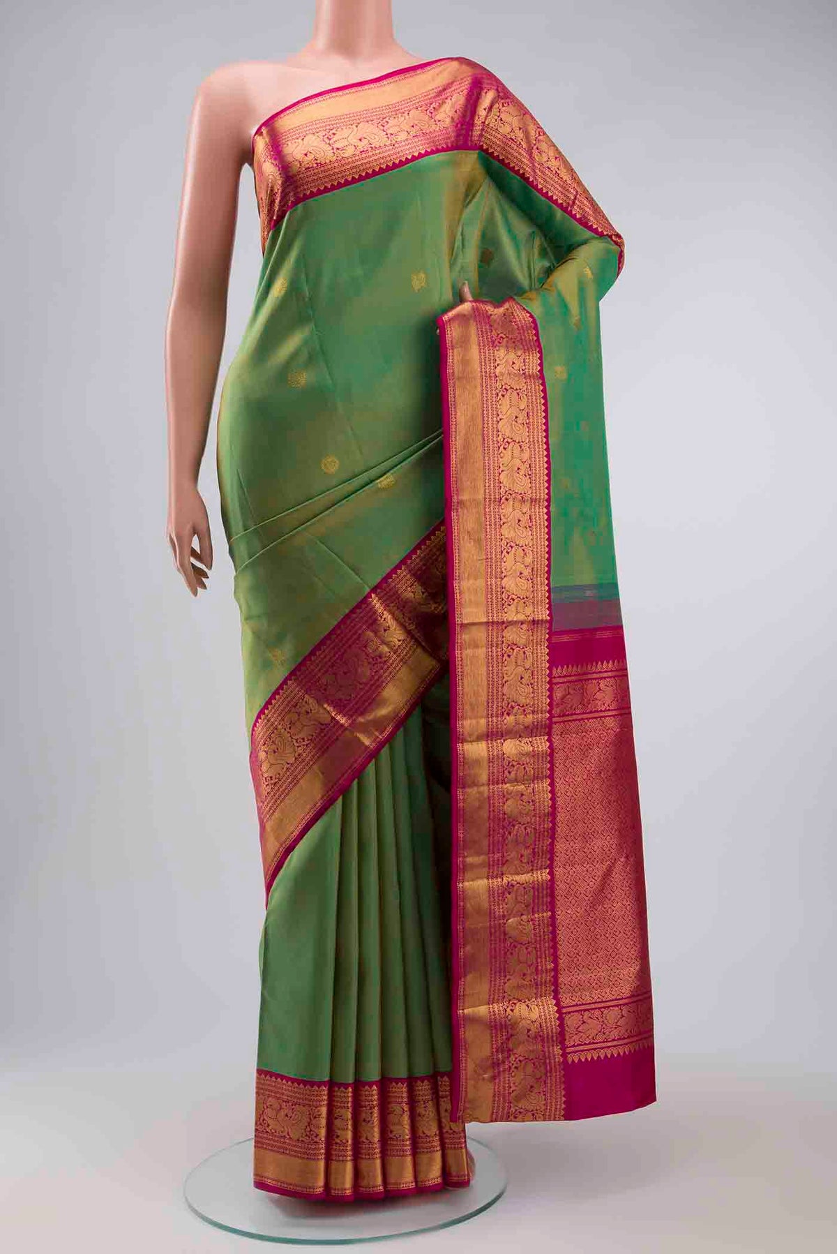 Green Kanchipuram Silk Saree with Zari Butta on the body and Zari Border displayed on a mannequin