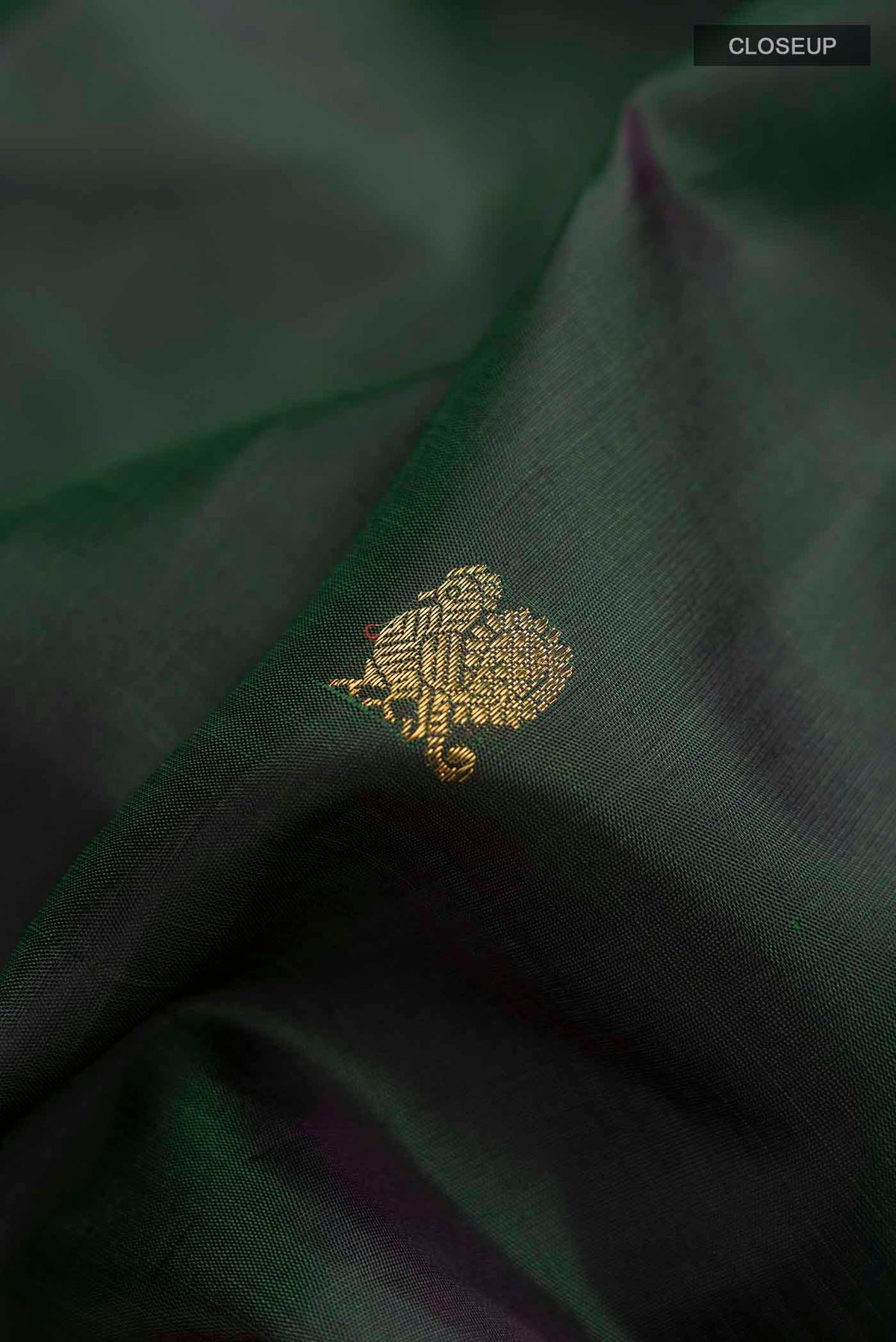 Close up of Green Kanchipuram Silk Saree with Zari Butta on the body and Zari Border displaying folds