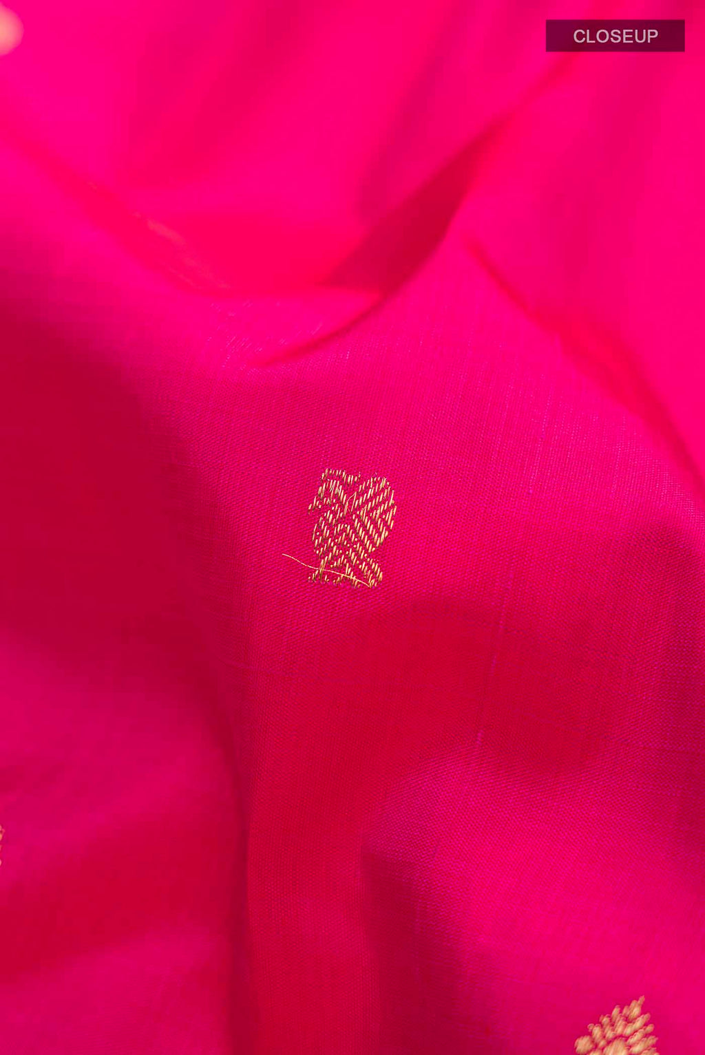 Close up of Pink Kanchipuram Silk Saree with Zari Butta on the body and Zari Border displaying folds