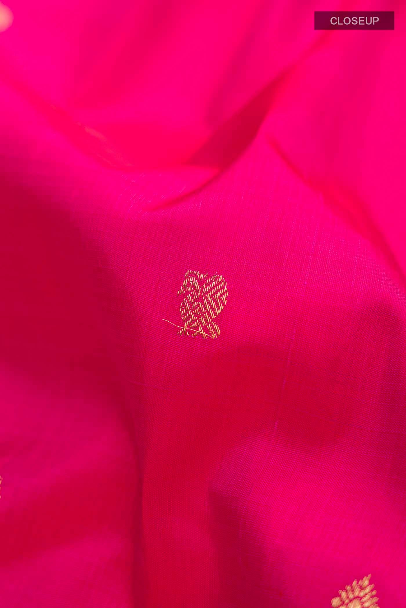 Close up of Pink Kanchipuram Silk Saree with Zari Butta on the body and Zari Border displaying folds