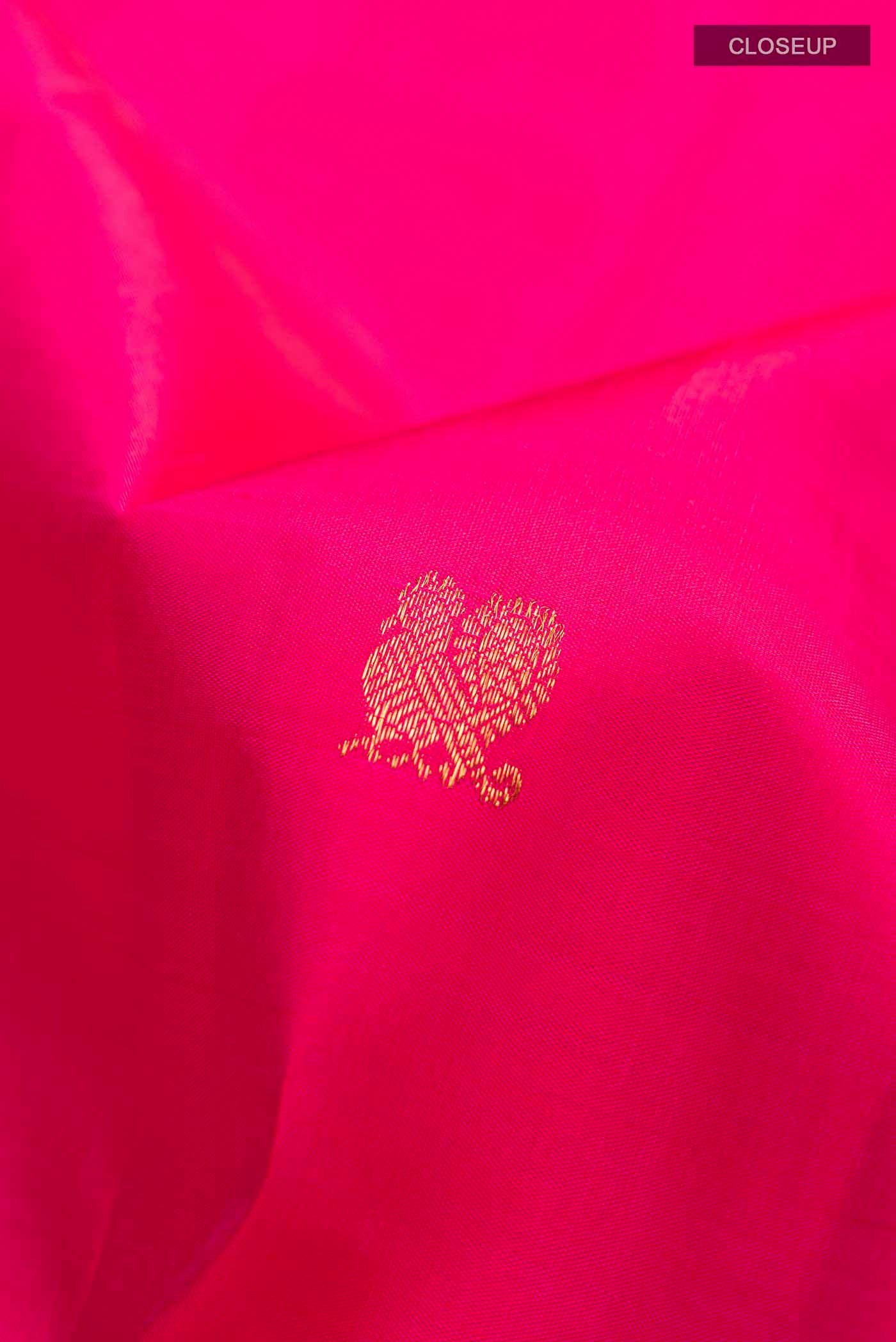 Close up of Pink Kanchipuram Silk Saree with Zari Butta on the body and Zari Border displaying folds