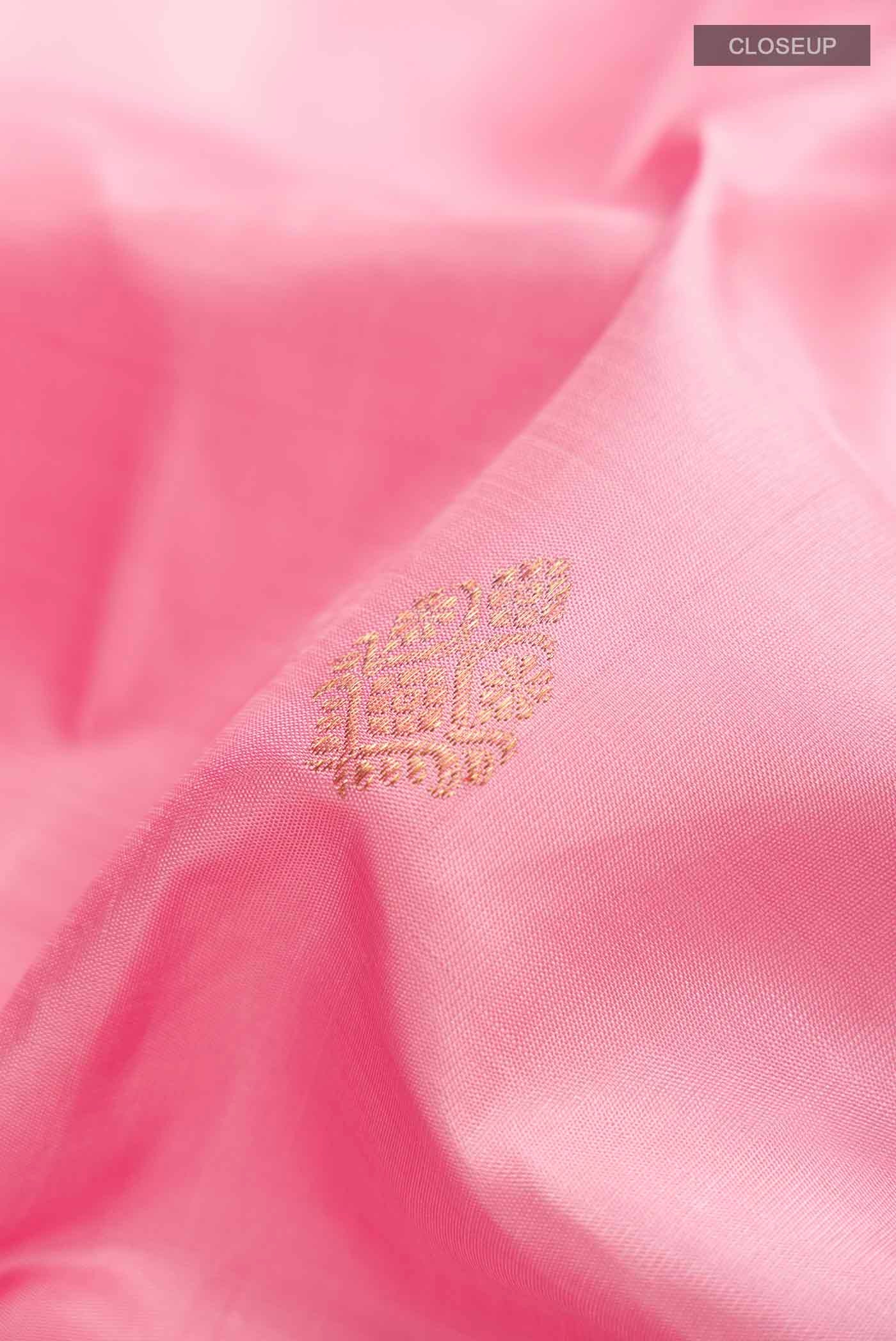 Close up of Pink Kanchipuram Silk Saree with Zari Butta on the body and Zari Border displaying folds