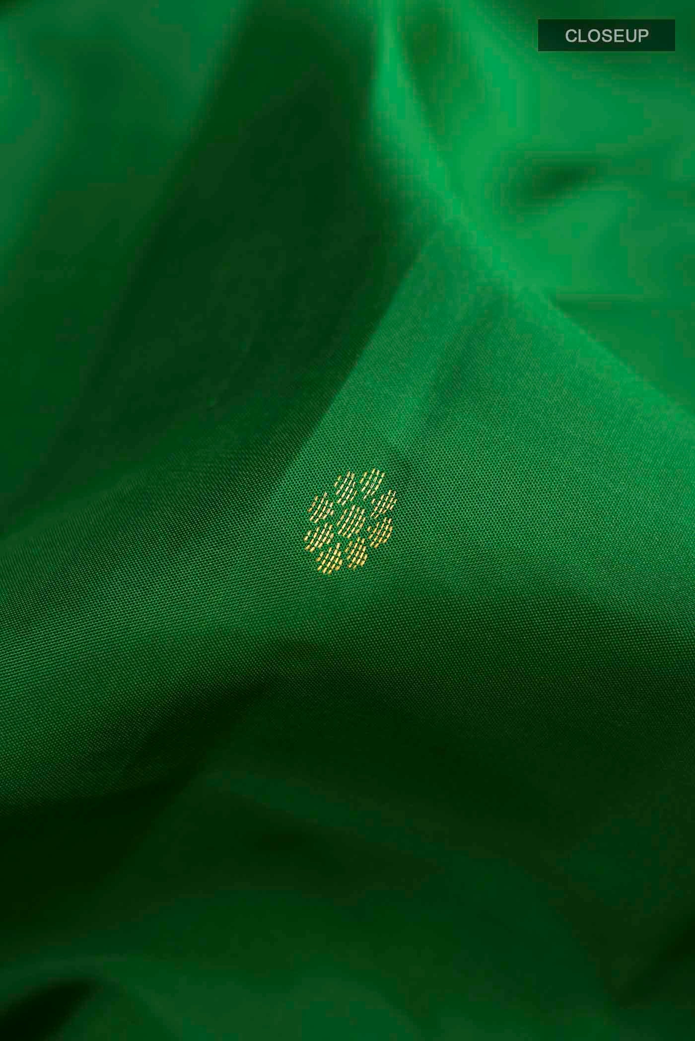 Close up of Green Kanchipuram Silk Saree with Zari Butta on the body and Zari Border displaying folds