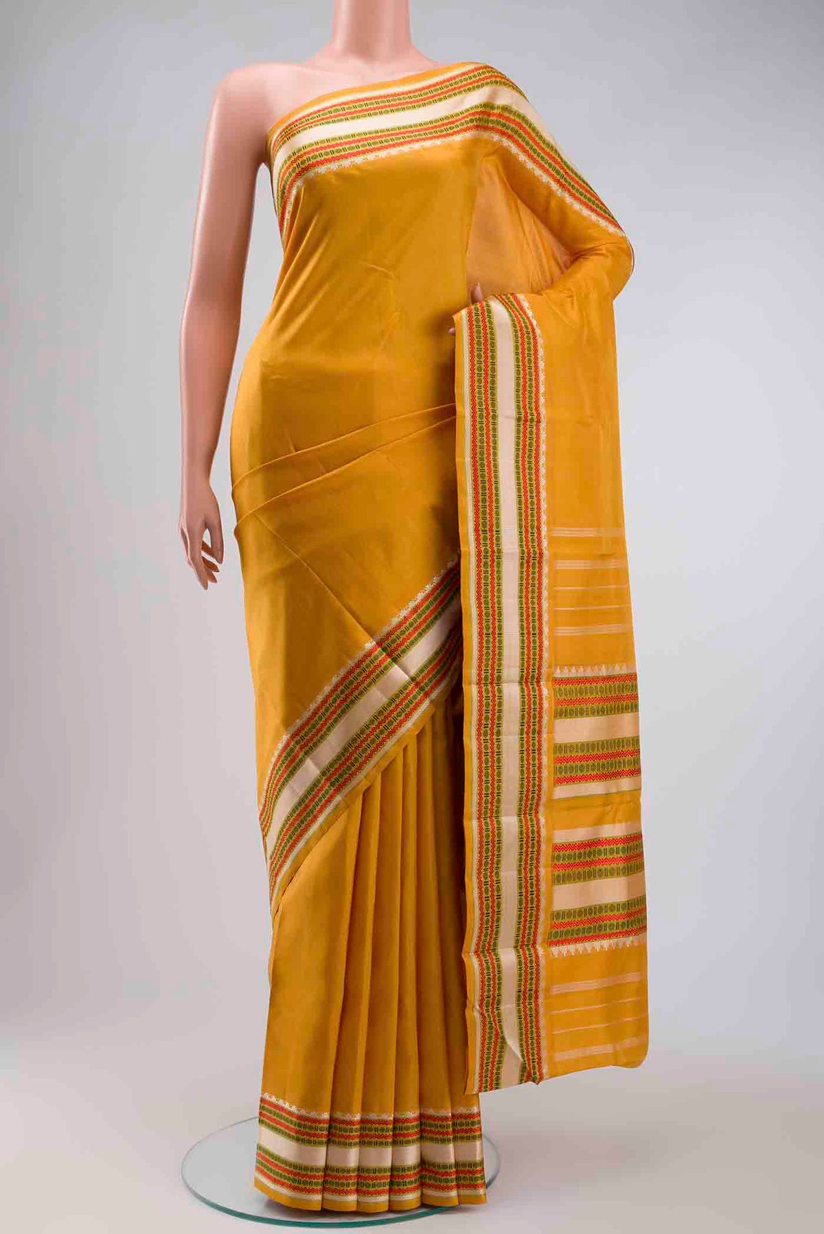 Mustard Kanchipuram Silk Saree with Plain Body and Thread Border displayed on a mannequin