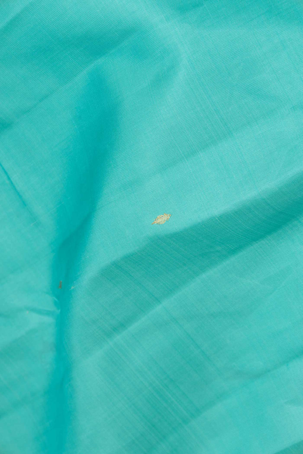 Close up of Sky Blue Dual Tone Kanchipuram Silk Saree with Zari Butta on the body and Zari Border displaying folds