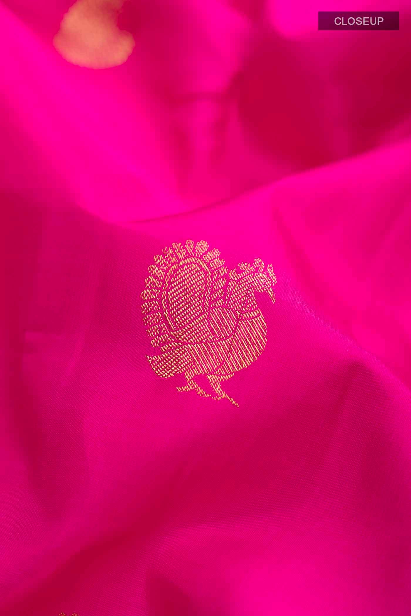 Close up of Pink Kanchipuram Silk Saree with Zari Butta on the body and Zari Border displaying folds