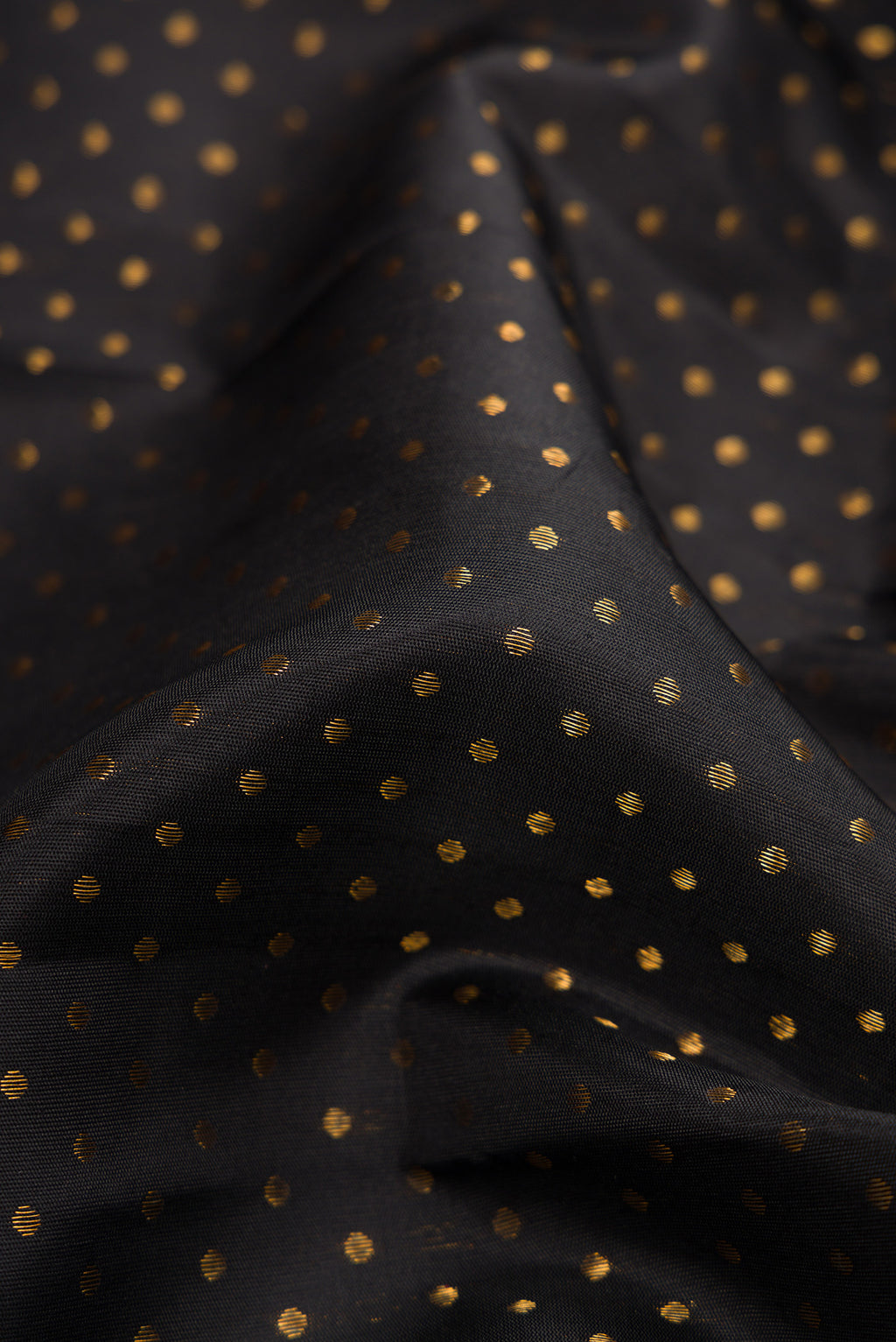 Close up of Pure Silk Pure Zari Black Dual Tone Kanjivaram Saree with Zari Butta on the body and Fancy Border.  displaying folds
