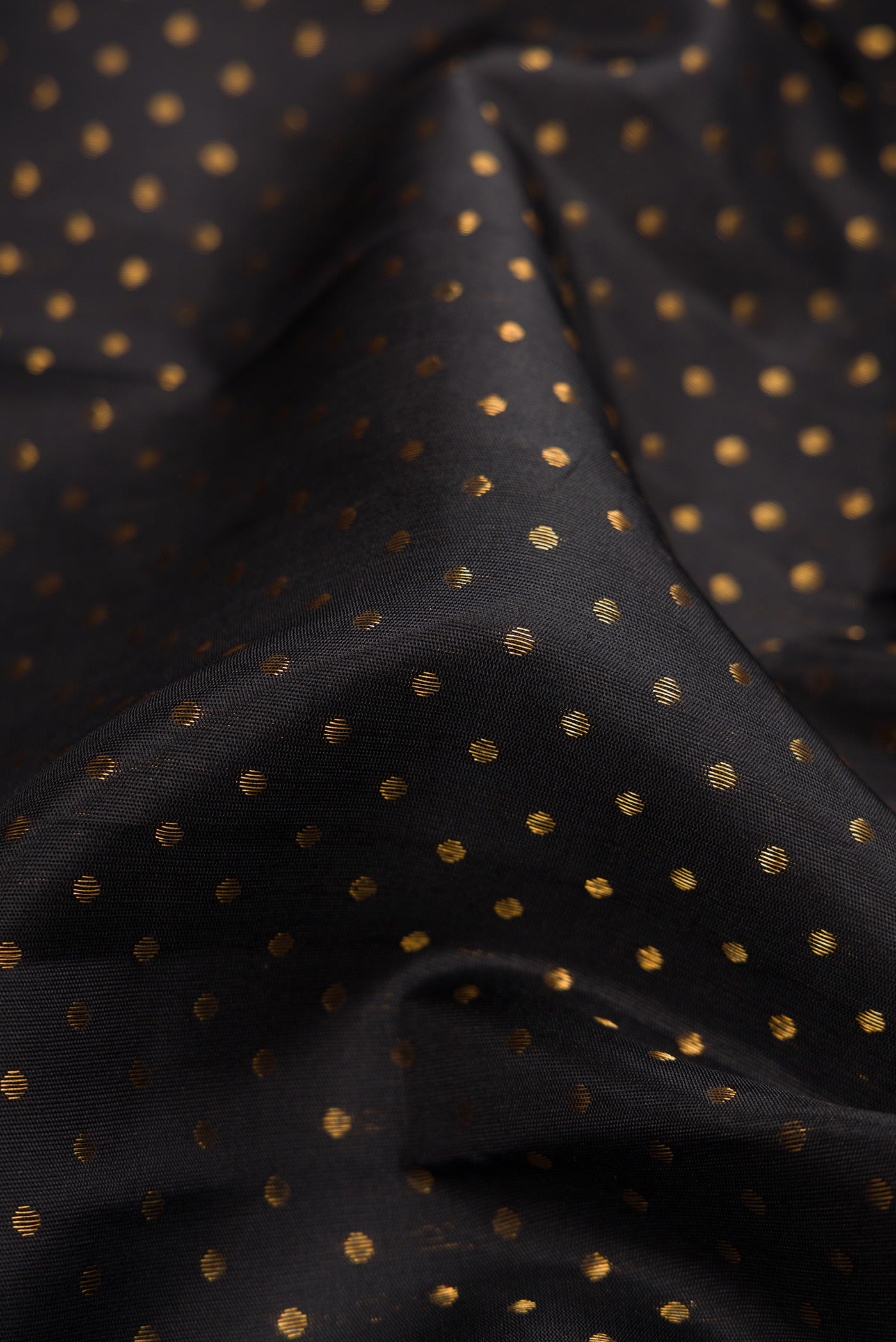 Close up of Pure Silk Pure Zari Black Dual Tone Kanjivaram Saree with Zari Butta on the body and Fancy Border.  displaying folds