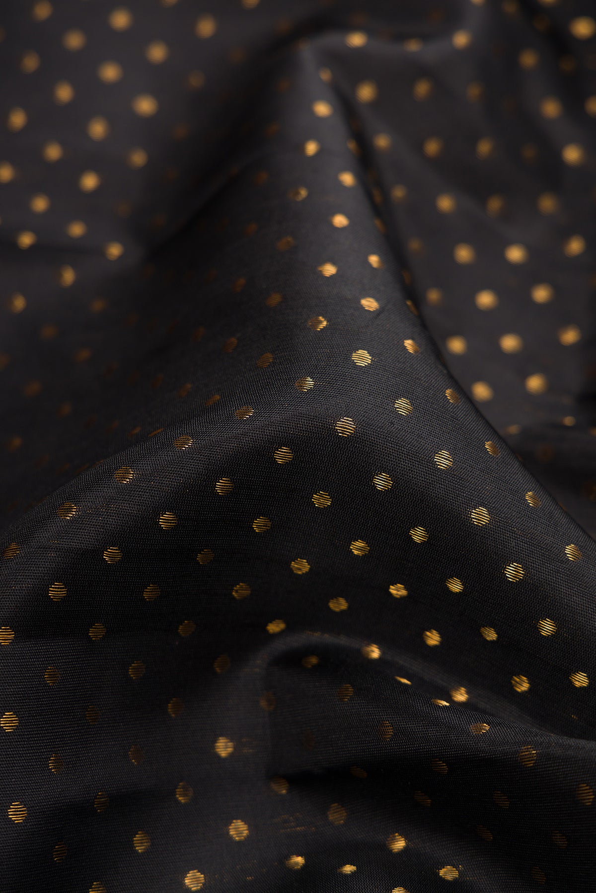 Close up of Pure Silk Pure Zari Black Dual Tone Kanjivaram Saree with Zari Butta on the body and Fancy Border.  displaying folds