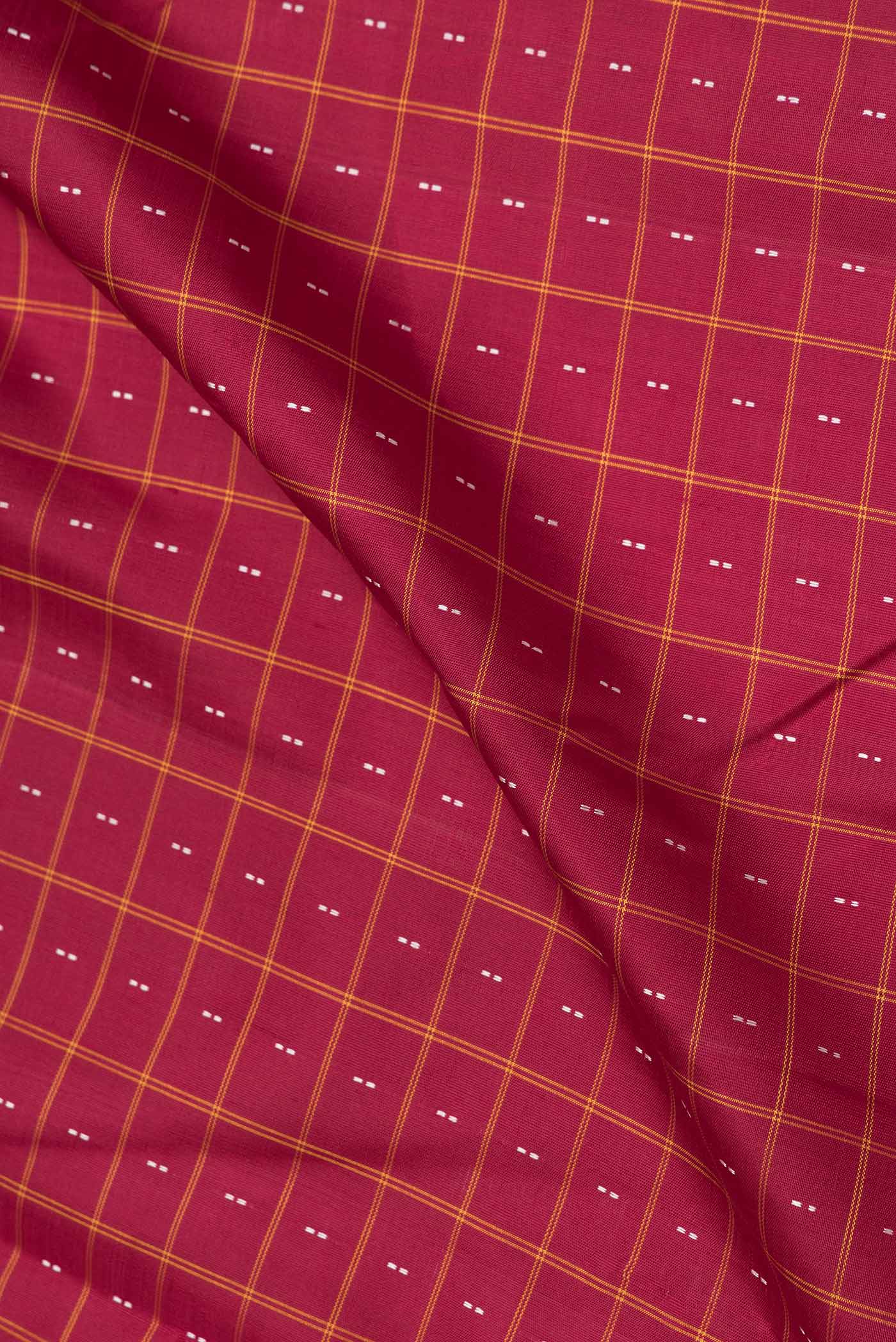 Close up of Maroon Dual Tone Kanchipuram Saree with Checked design on the body and Thread Border.  displaying folds