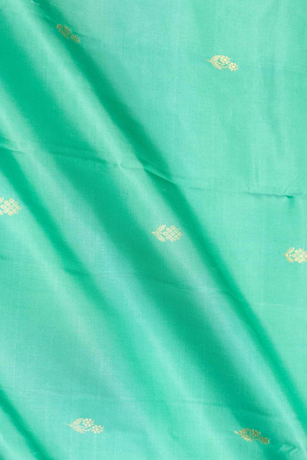 Close up of Green Dual Tone Kanchipuram Saree with Zari Butta on the body and Zari Border.  displaying folds