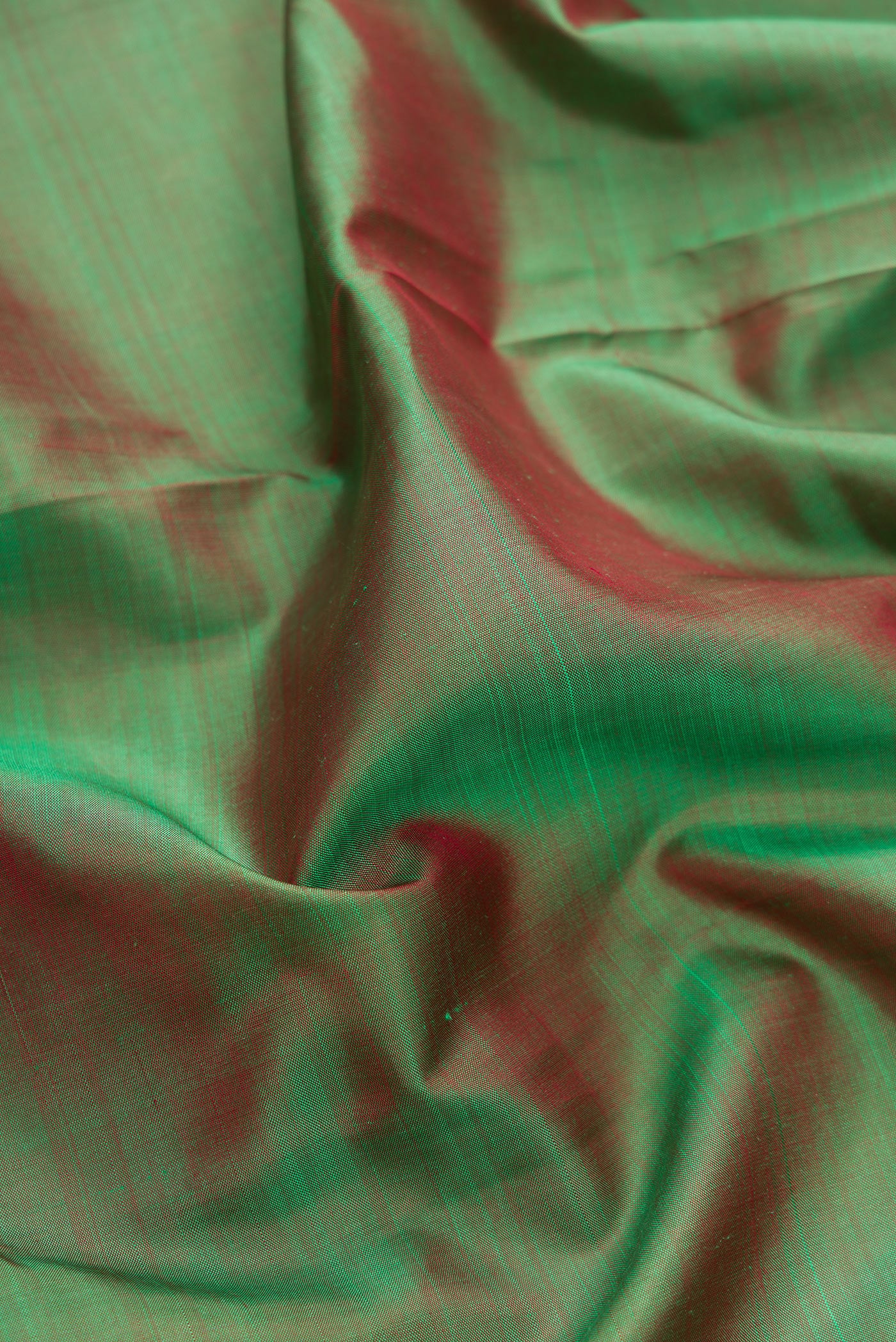 Close up of Green Dual Tone Kanchipuram Silk Saree with Plain Body and Temple Border.  displaying folds