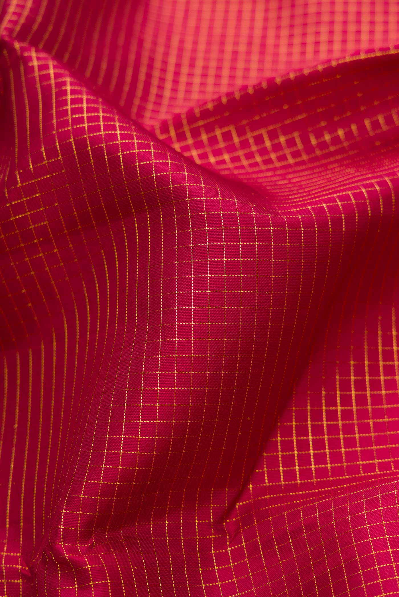 Close up of Maroon Dual Tone Kanchipuram Silk Saree with Checked design on the body and Zari Border displaying folds