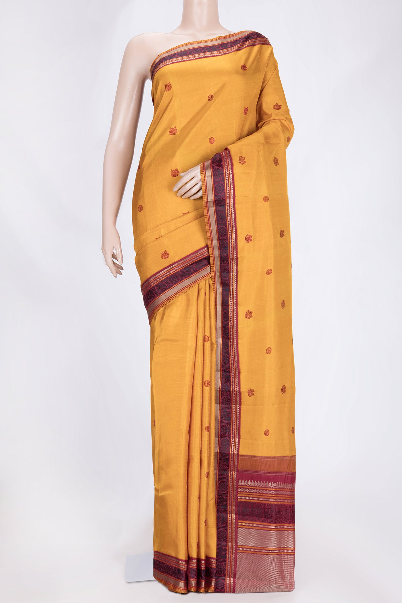 Mustard Dual Tone Kanjivaram Saree with Thread Butta on the body and Thread Border.  displayed on a mannequin