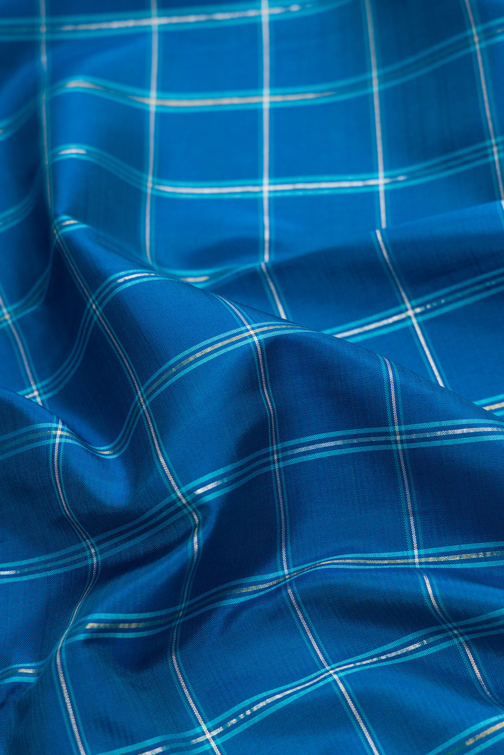 Close up of Pure Silk Pure Zari Peacock Blue Dual Tone Kanjivaram Saree with Checked design on the body and Zari Border.  displaying folds