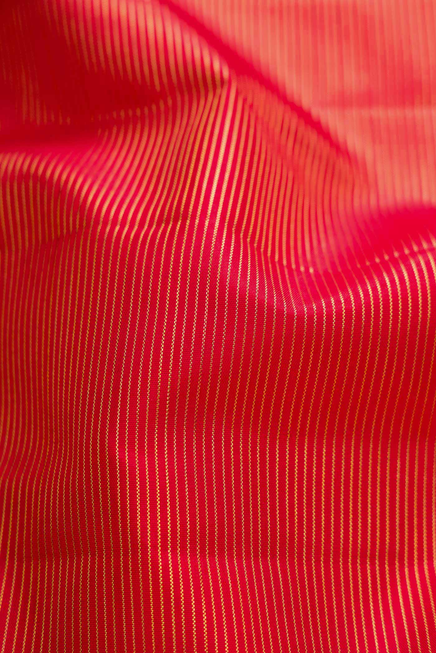 Close up of Red Dual Tone Kanchipuram Silk Saree with Stripes on the body and Zari Border displaying folds