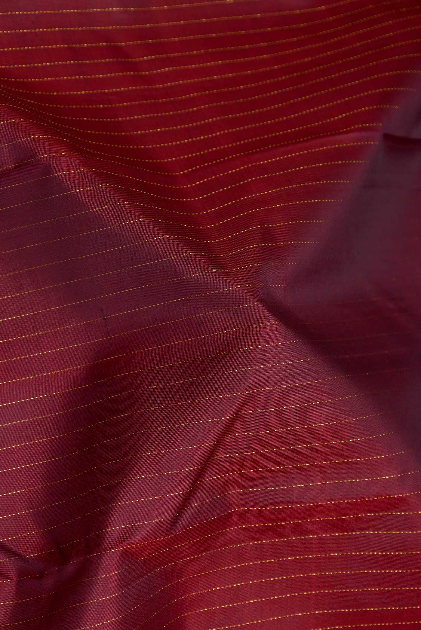 Close up of Maroon Dual Tone Kanchipuram Silk Saree with Stripes on the body and Zari Border displaying folds