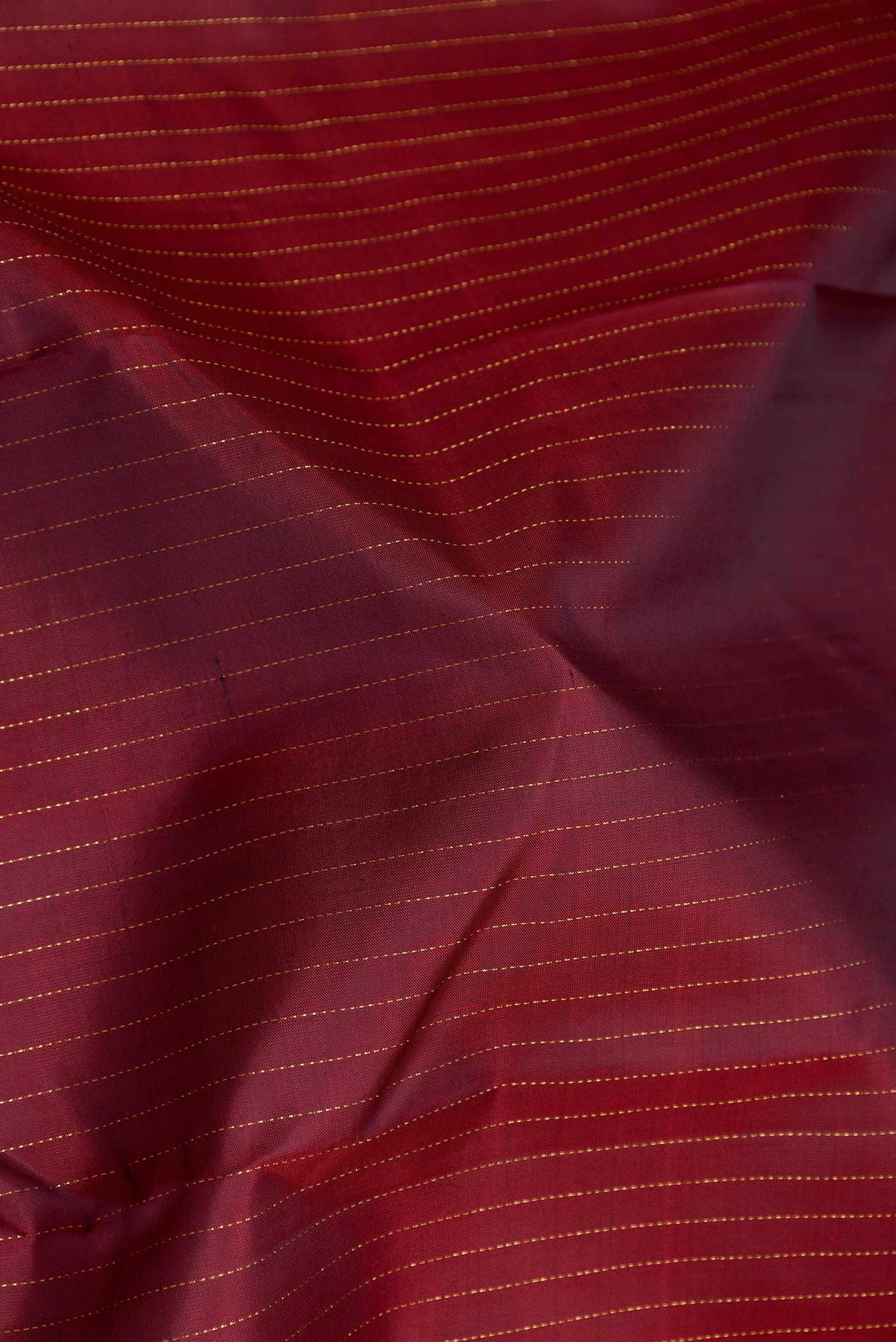 Close up of Maroon Dual Tone Kanchipuram Silk Saree with Stripes on the body and Zari Border displaying folds