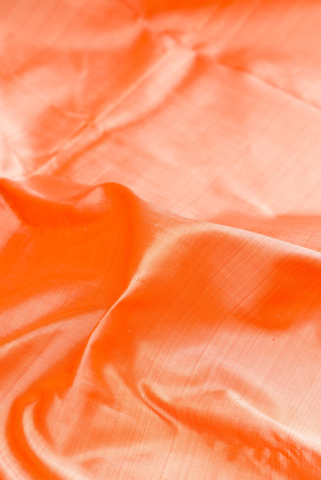 Close up of Pure Silk Pure Zari Golden Peach Dual Tone Kanjivaram Saree with Plain Body and One Side Border.  displaying folds
