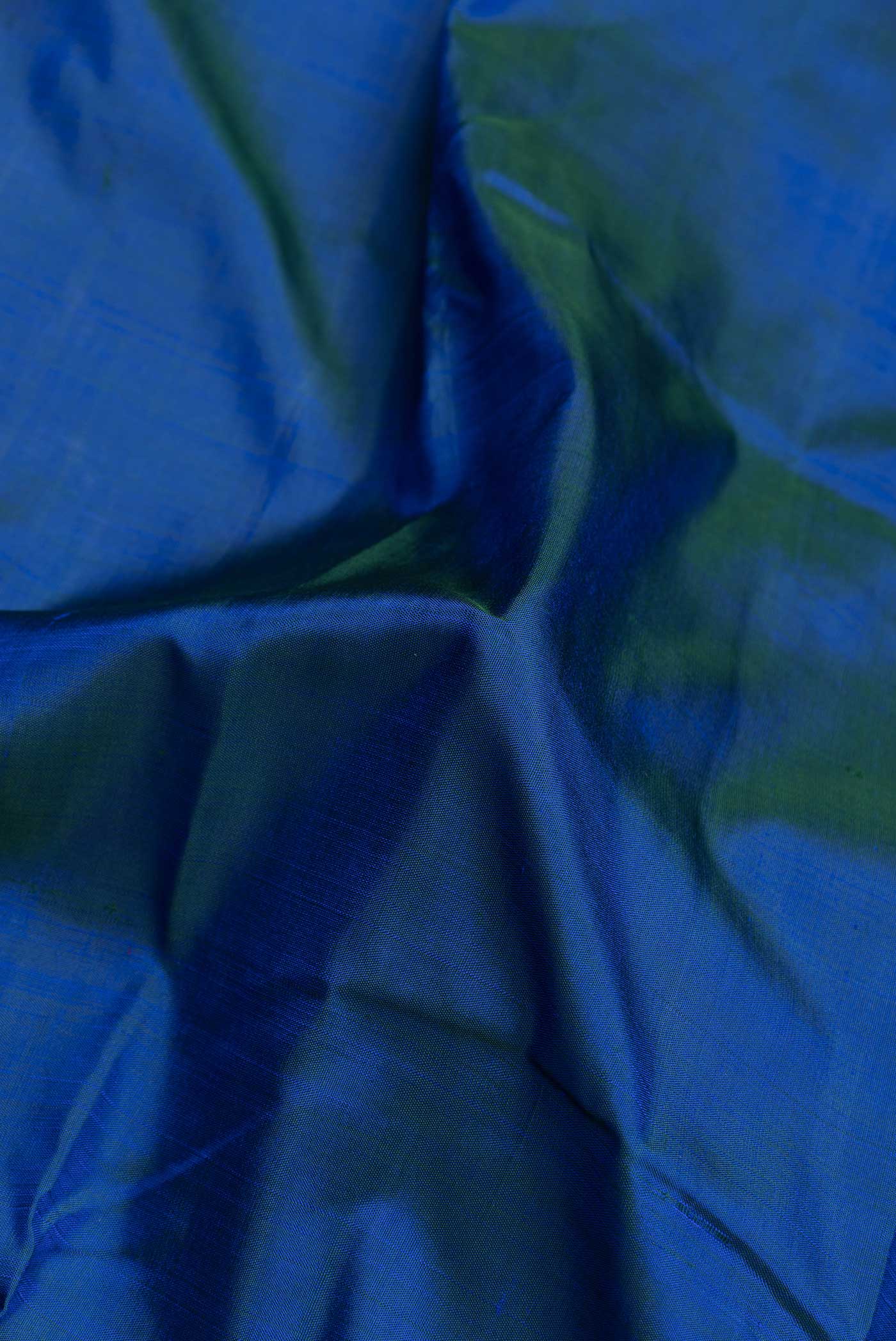 Close up of Peacock Blue Dual Tone Kanjivaram Saree with Plain Body and Zari Border.  displaying folds