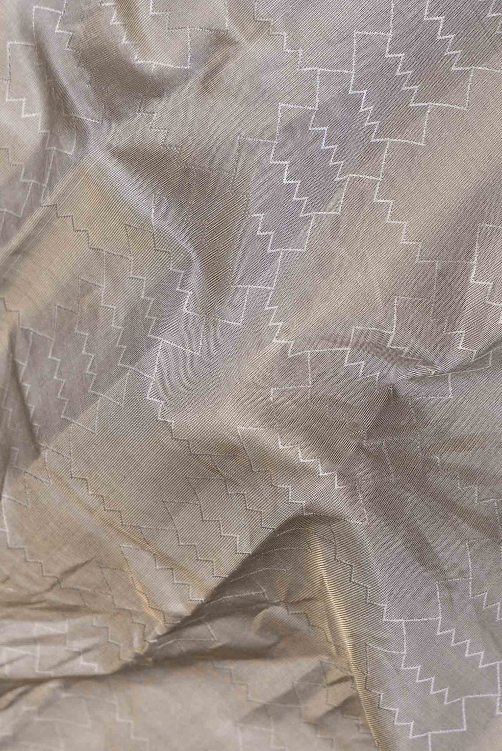 Close up of Grey Kanchipuram Silk Saree with Jacquard design on the body and Zari Border displaying folds