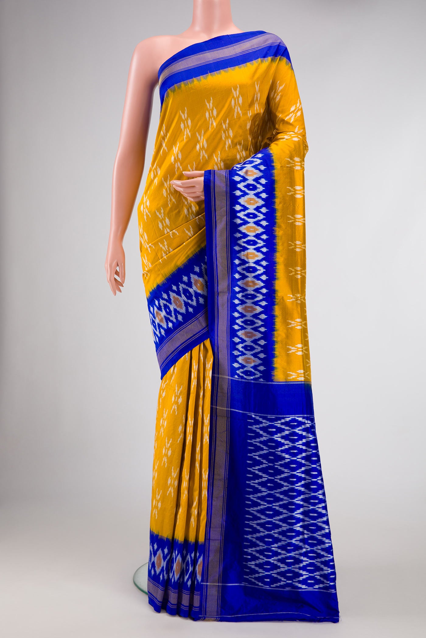 Mustard Dual Tone Double Ikat Saree with Ikat Print on the body and Ikat Border.  displayed on a mannequin