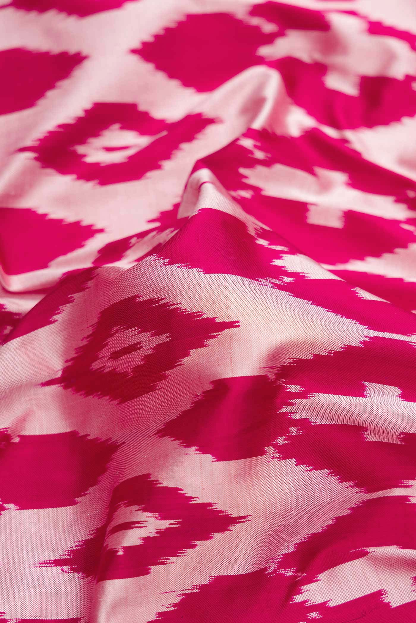 Close up of Pink Dual Tone Double Ikat Saree with Ikat Print on the body and Ikat Border.  displaying folds
