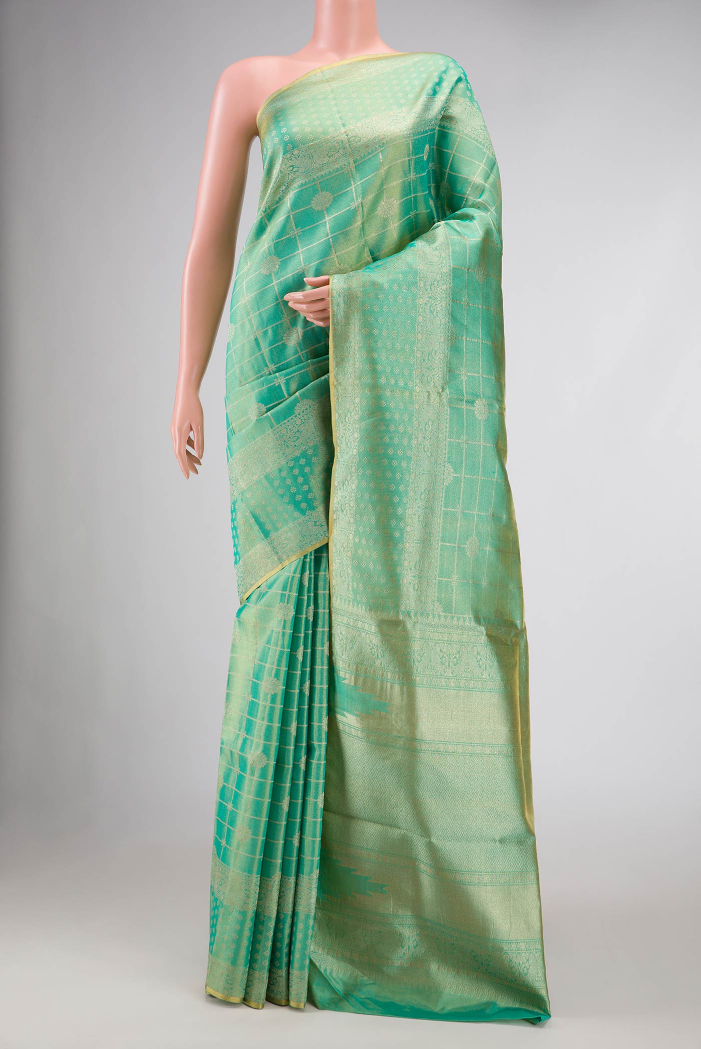 Sea Green Dual Tone Kanjivaram Tissue Silk Saree with Zari Brocade on the body and Zari Border.  displayed on a mannequin