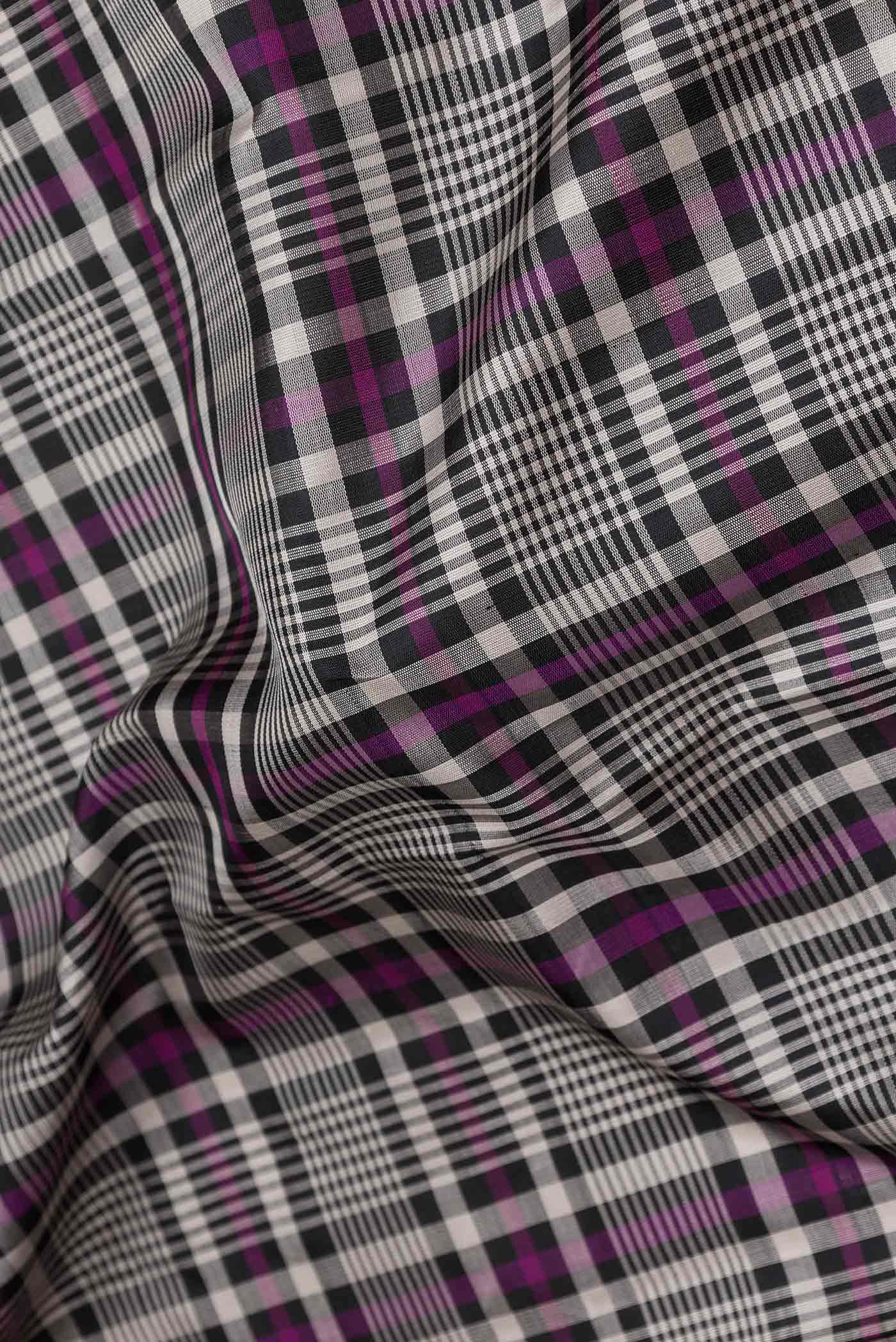 Close up of Black and Magenta Color Kanchipuram Silk Saree with Checked design on the body and Zari Border displaying folds