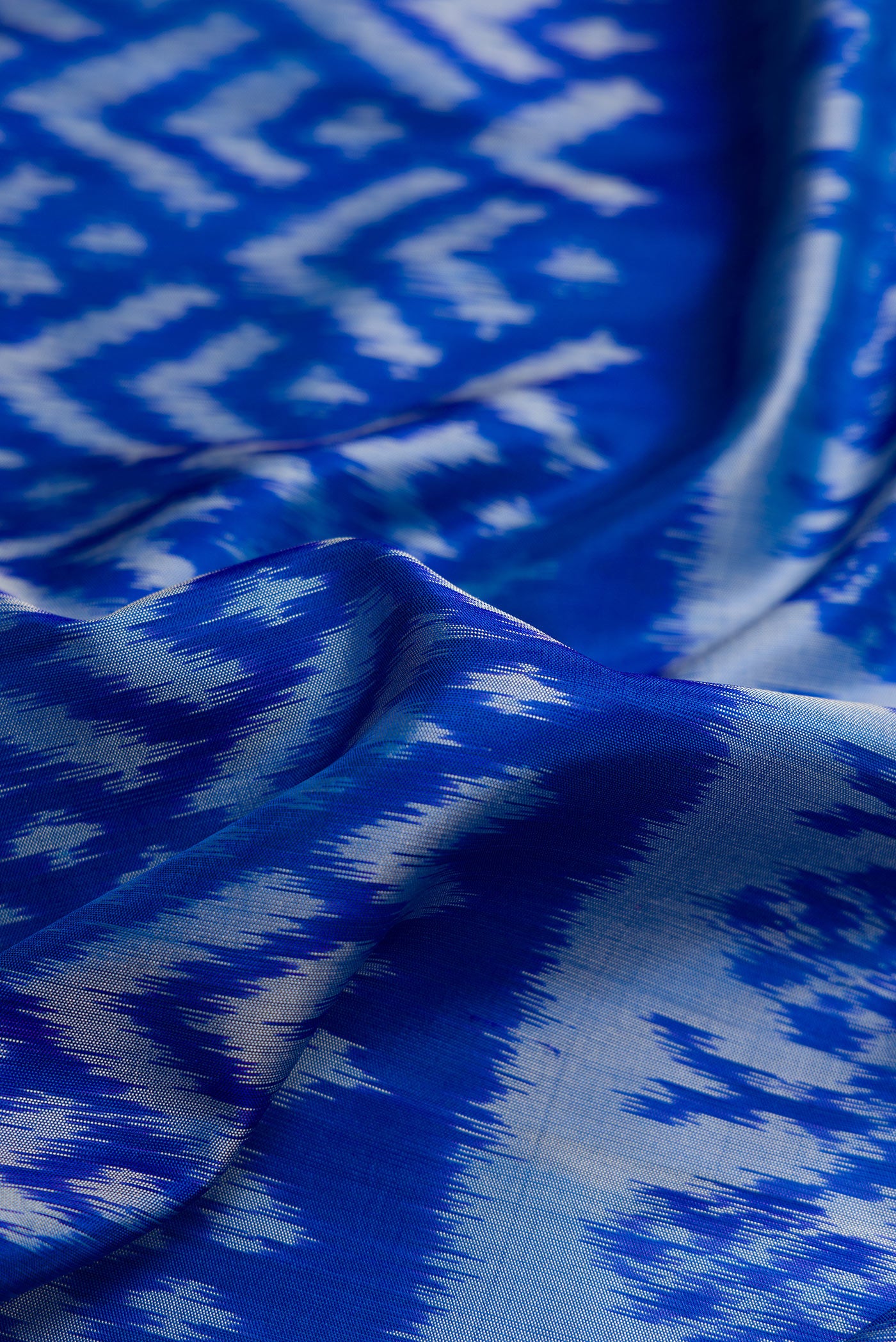 Close up of Royal Blue Dual Tone Soft Silk Saree with Ikat Print on the body and Ikat Border.  displaying folds