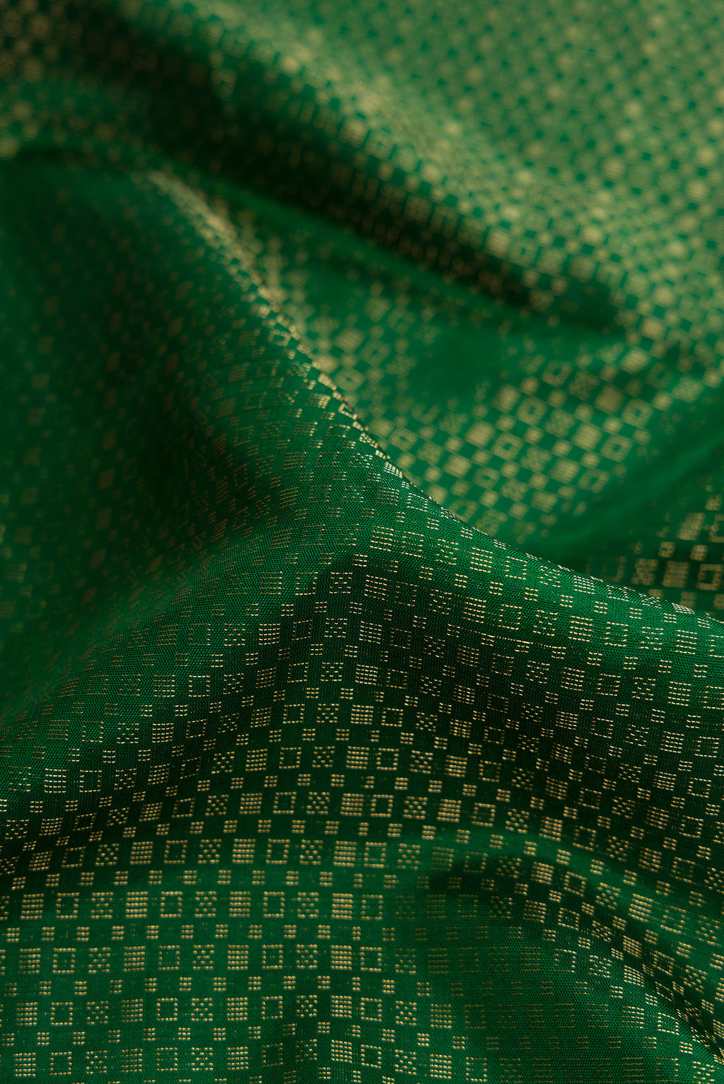 Close up of Bottle Green Dual Tone Soft Silk Saree with Zari Brocade on the body and Ikat Border.  displaying folds
