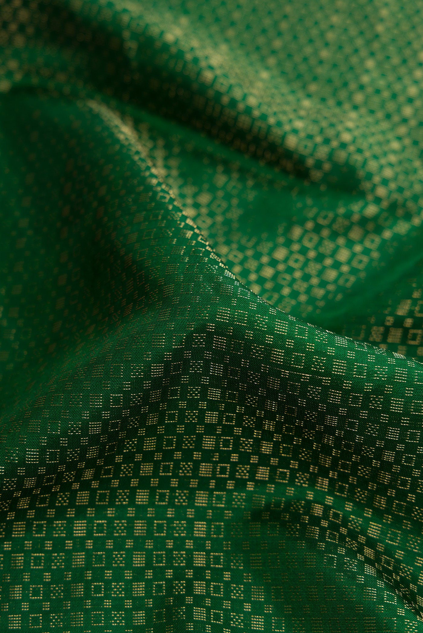 Close up of Bottle Green Dual Tone Soft Silk Saree with Zari Brocade on the body and Ikat Border.  displaying folds