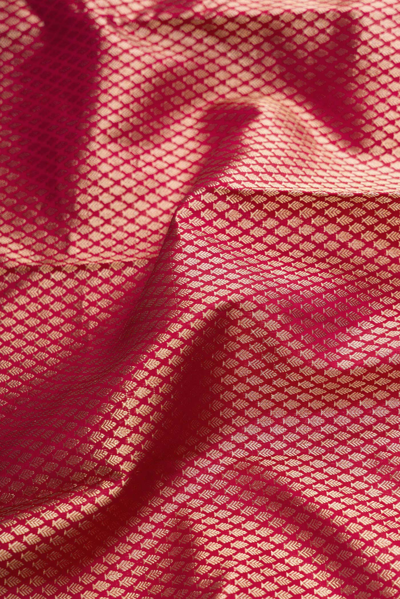 Close up of Maroon Dual Tone Kanjivaram Silk Saree with Zari Brocade on the body and Zari Border.  displaying folds