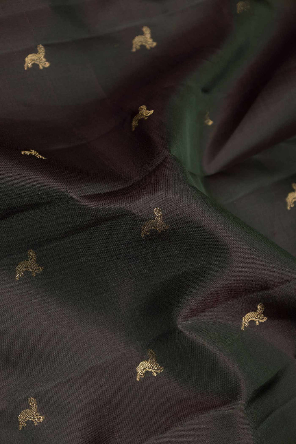 Close up of Bottle Green Dual Tone Kanchipuram Silk Saree with Zari Butta on the body and Zari Border displaying folds
